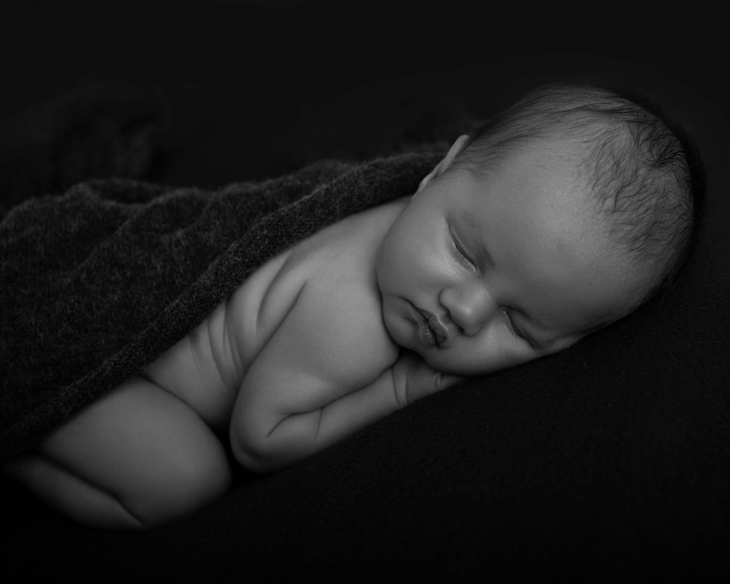 Black and White Photo of a sleeping baby boy for his newborn photography session