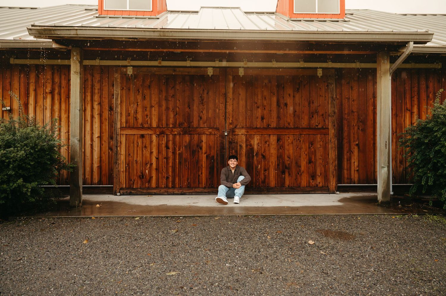 Long panoramic view of a rustic wooden barn exterior with orange trim.