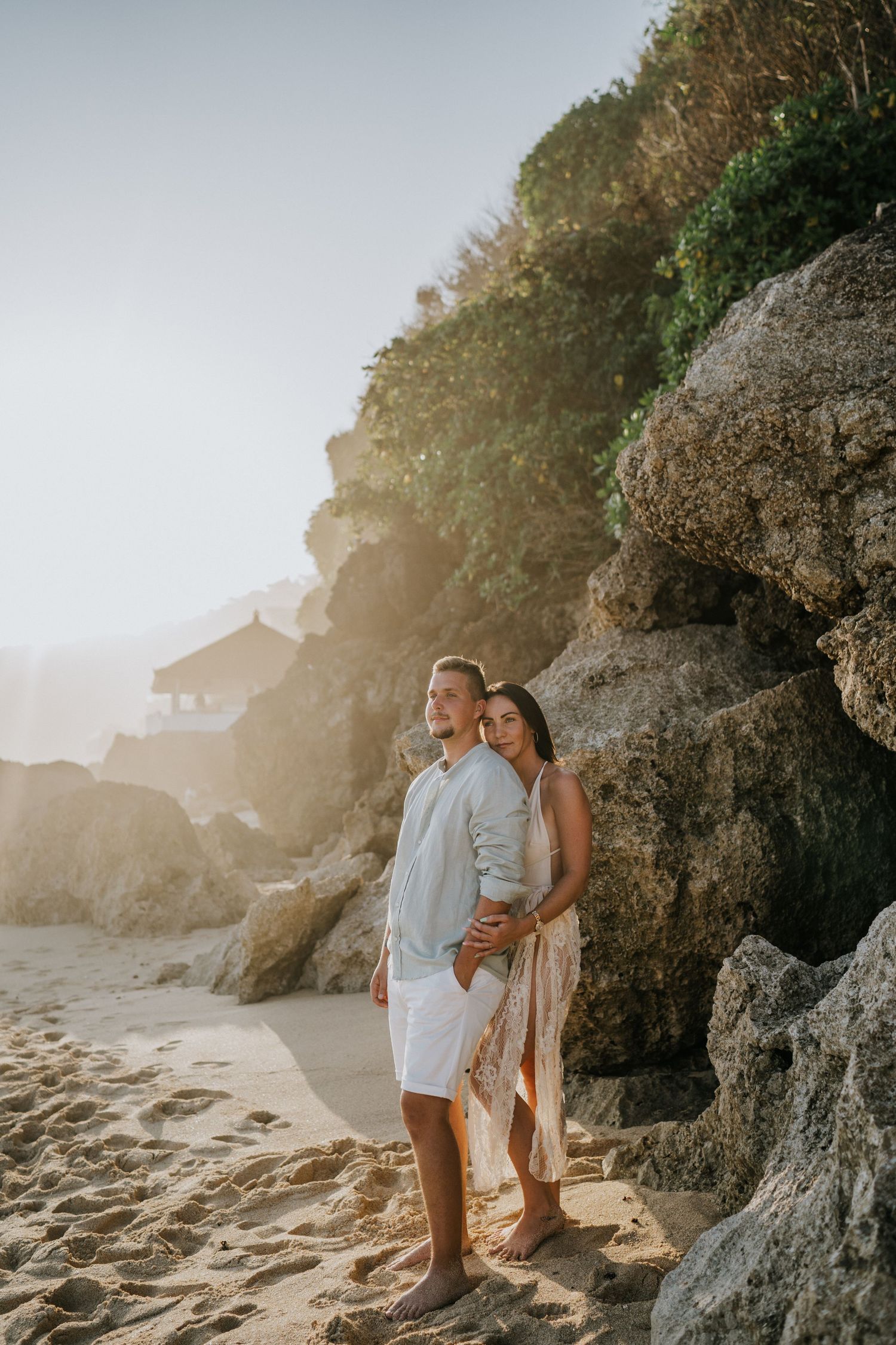 Romantic beach photoshoot with couple at sunset.