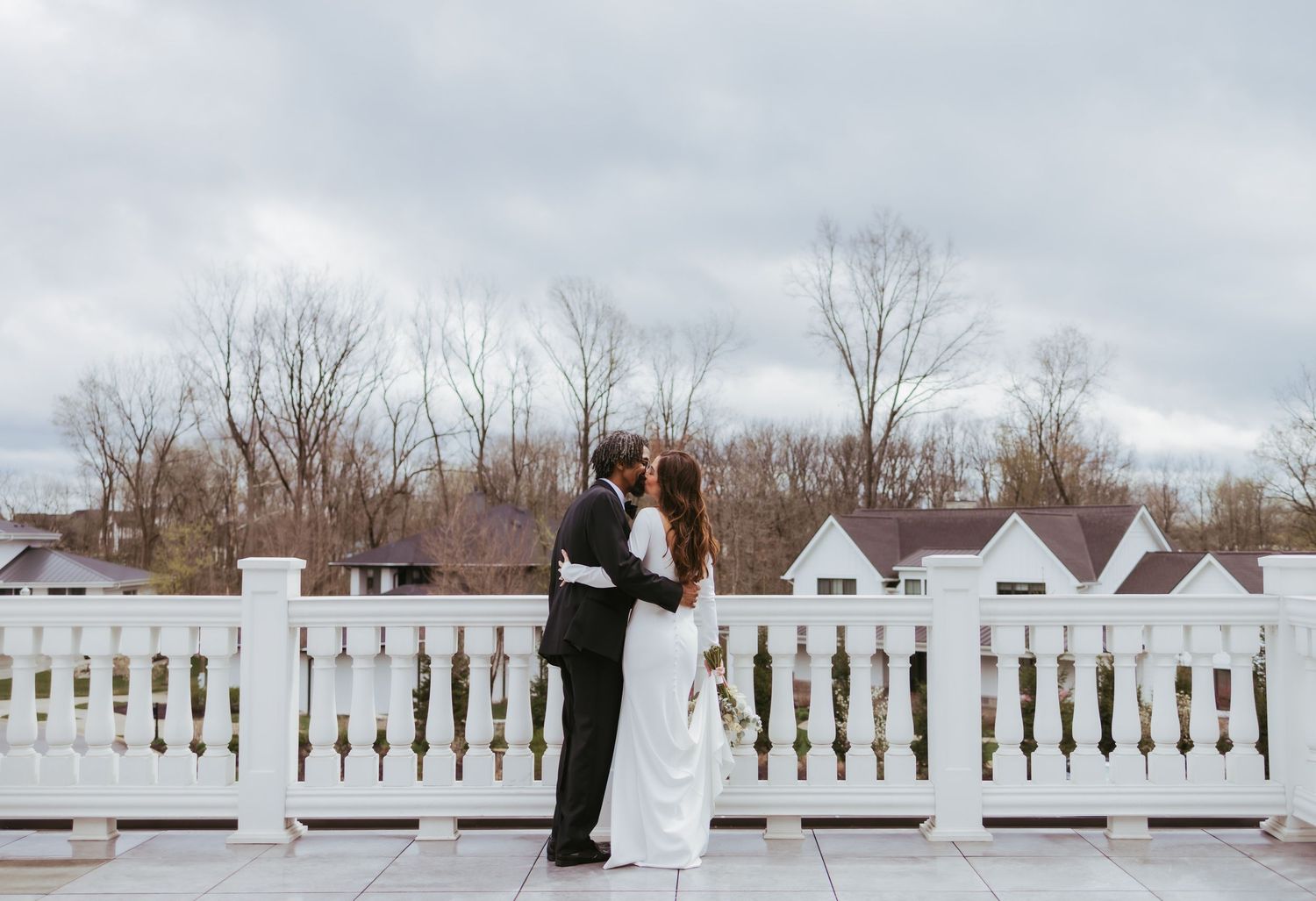 Bride and groom, wedding portrait kissing on a windy day at Holliday Farms in Zionsville, Indiana