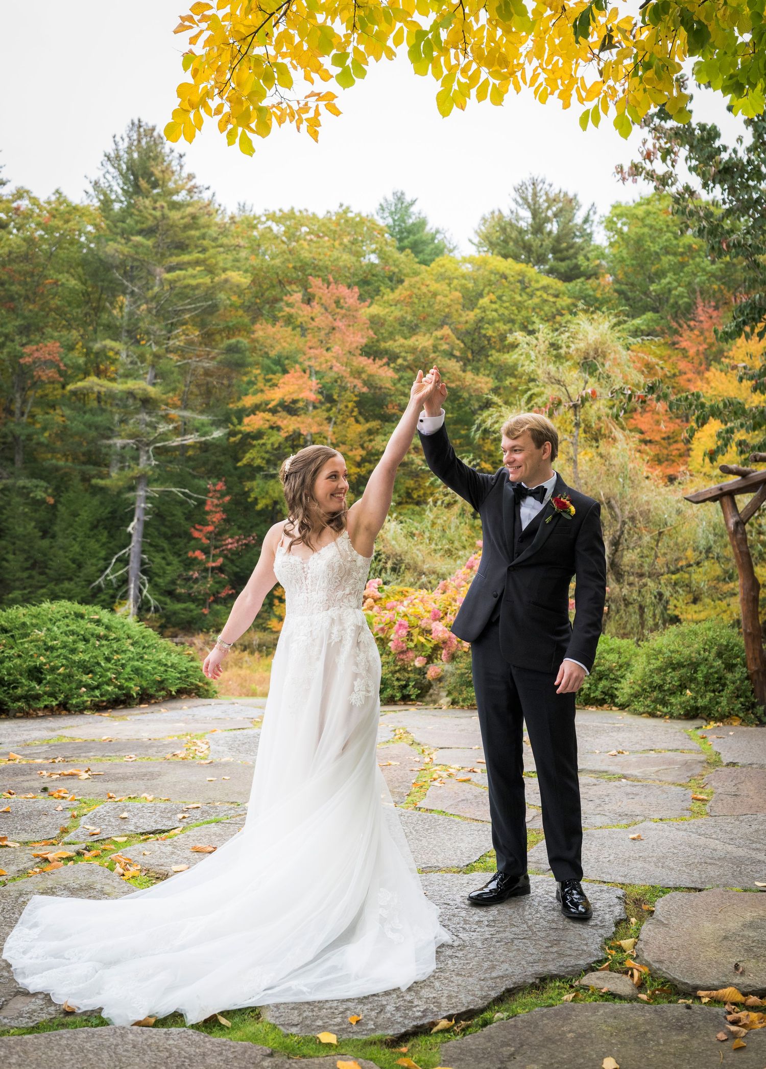 Bride and groom share a romantic moment outdoors in autumn, surrounded by colorful fall foliage on their wedding day.
