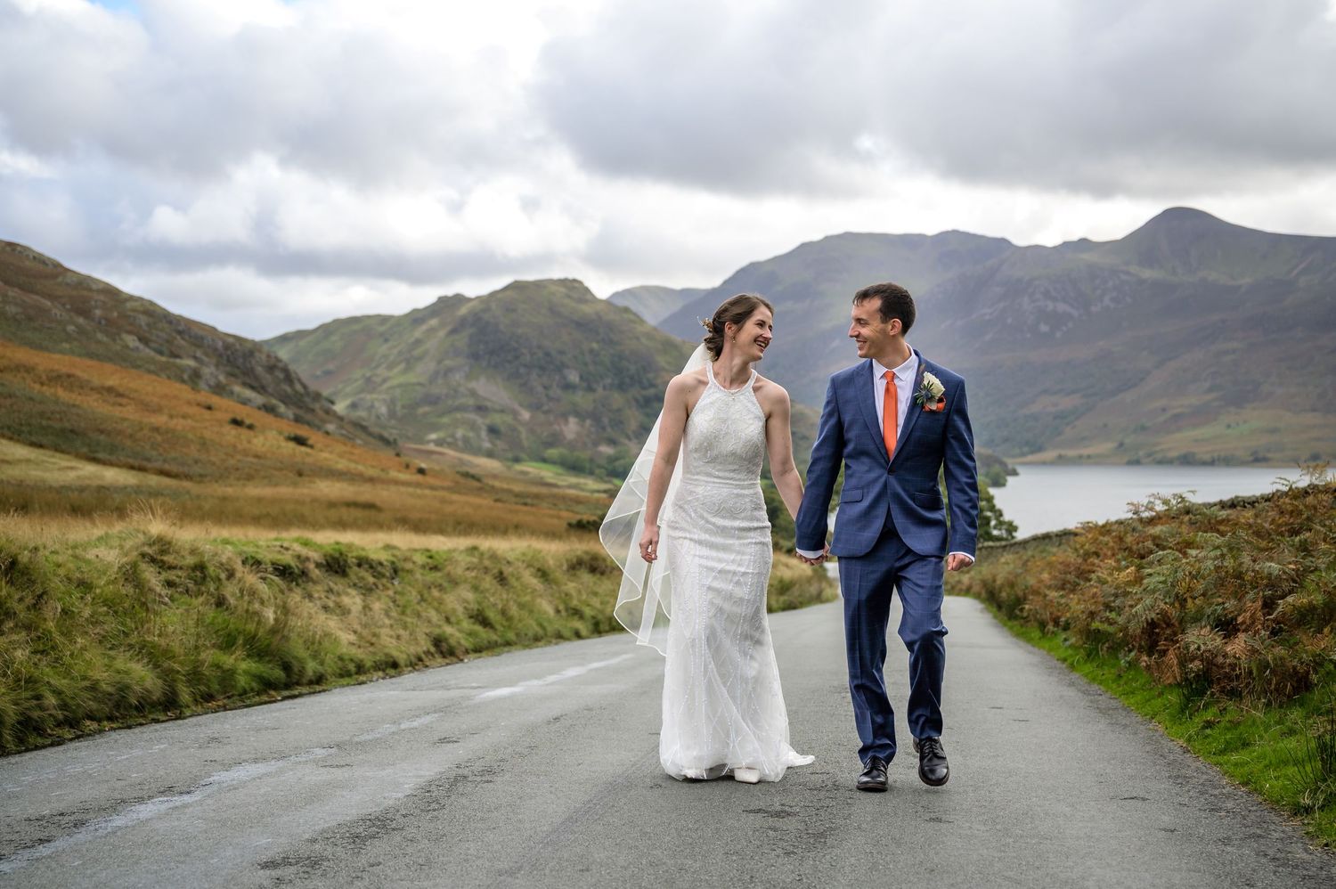 Bride and groom walking up road in the Lake District