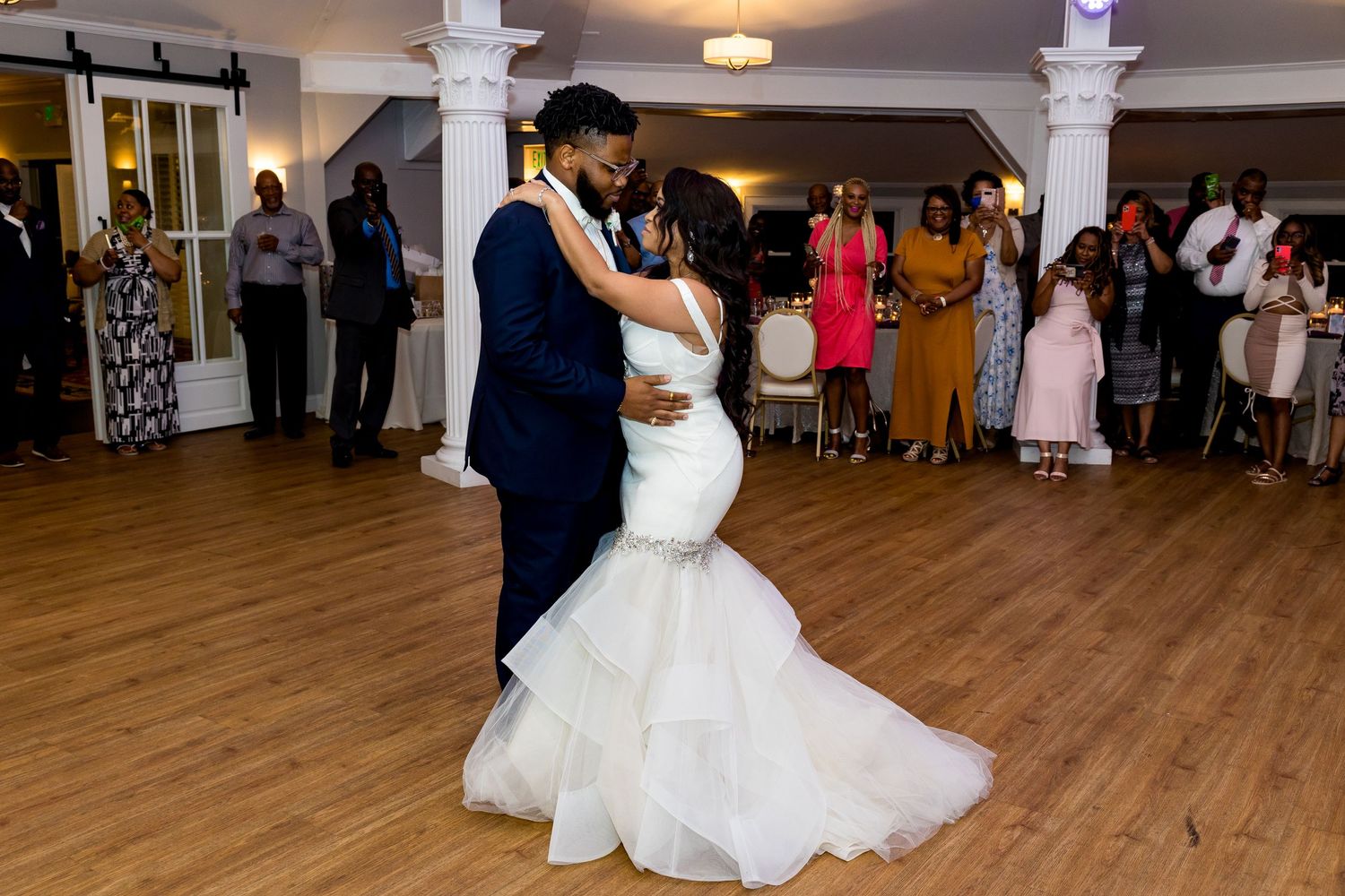 A couple dances in an elegant ballroom during their wedding first dance.