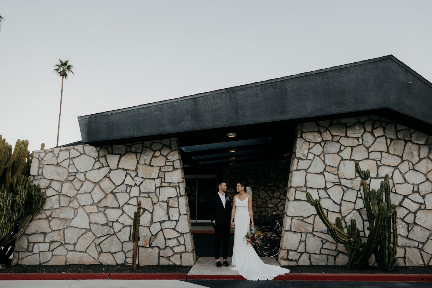 Modern stone facade building entrance decorated for an elegant wedding ceremony.