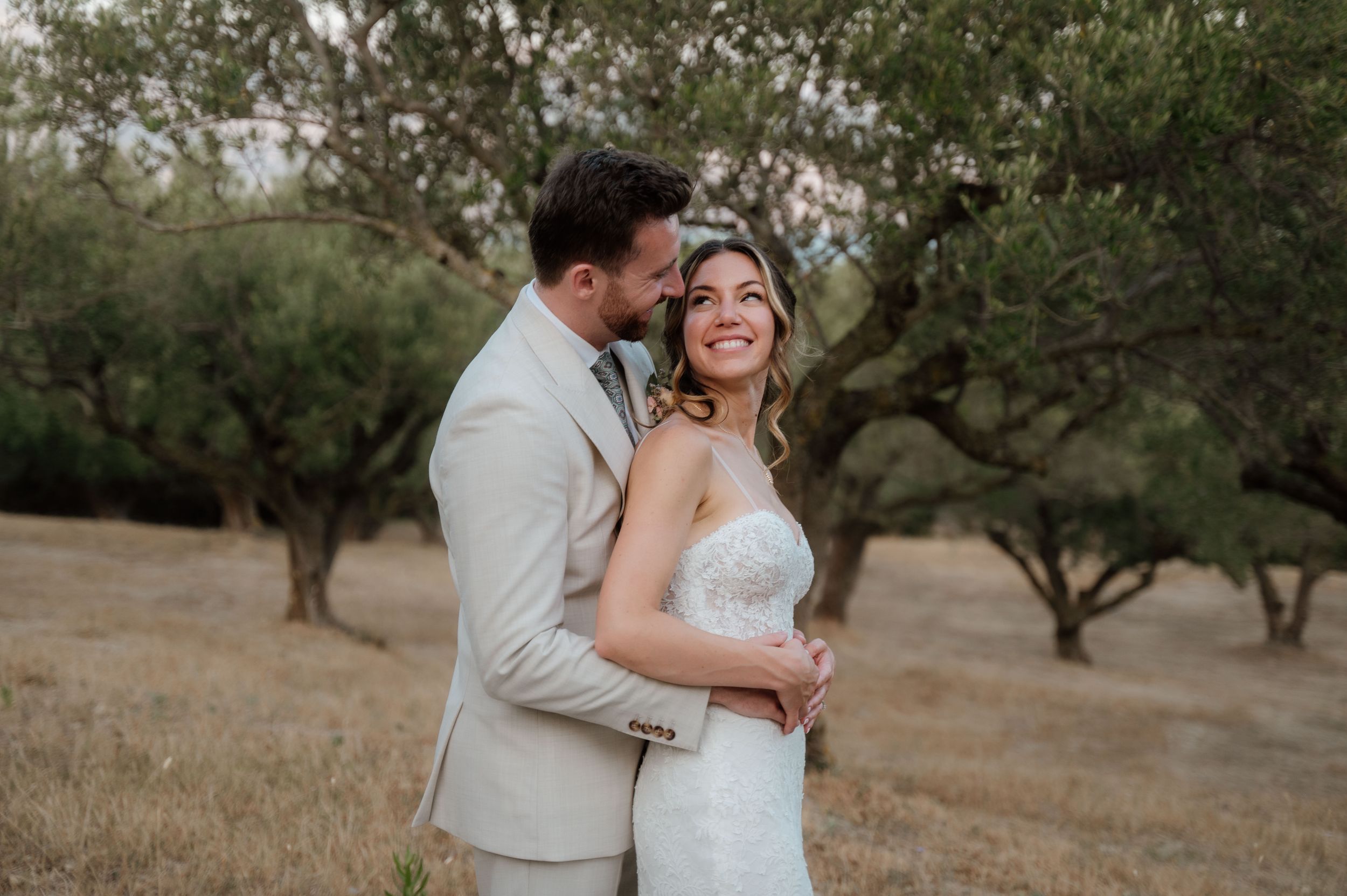 An intimate portrait of a bride and groom in an olive grove after their wedding in Corfu Greece
