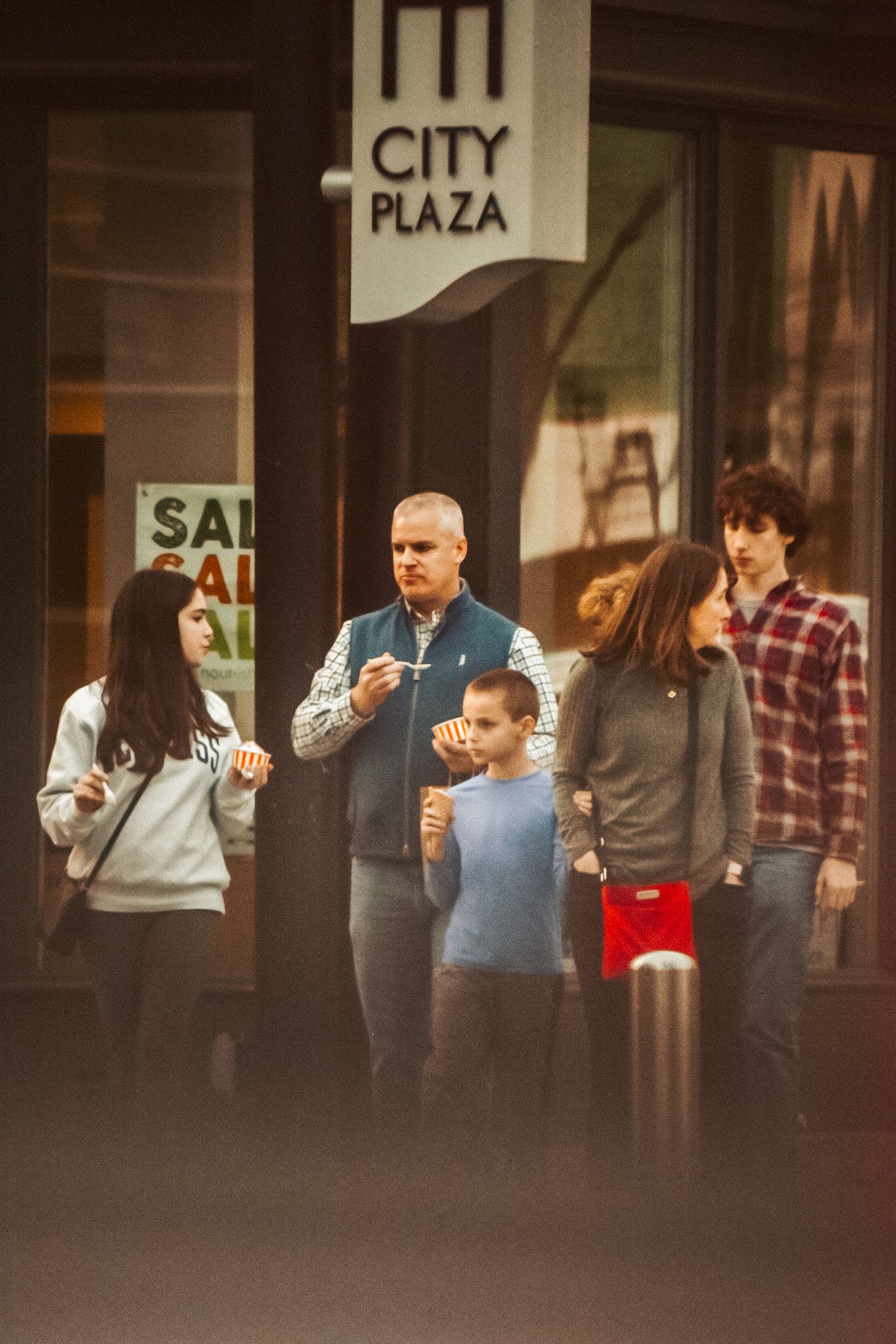 Several people gathered outside a City Plaza entrance.