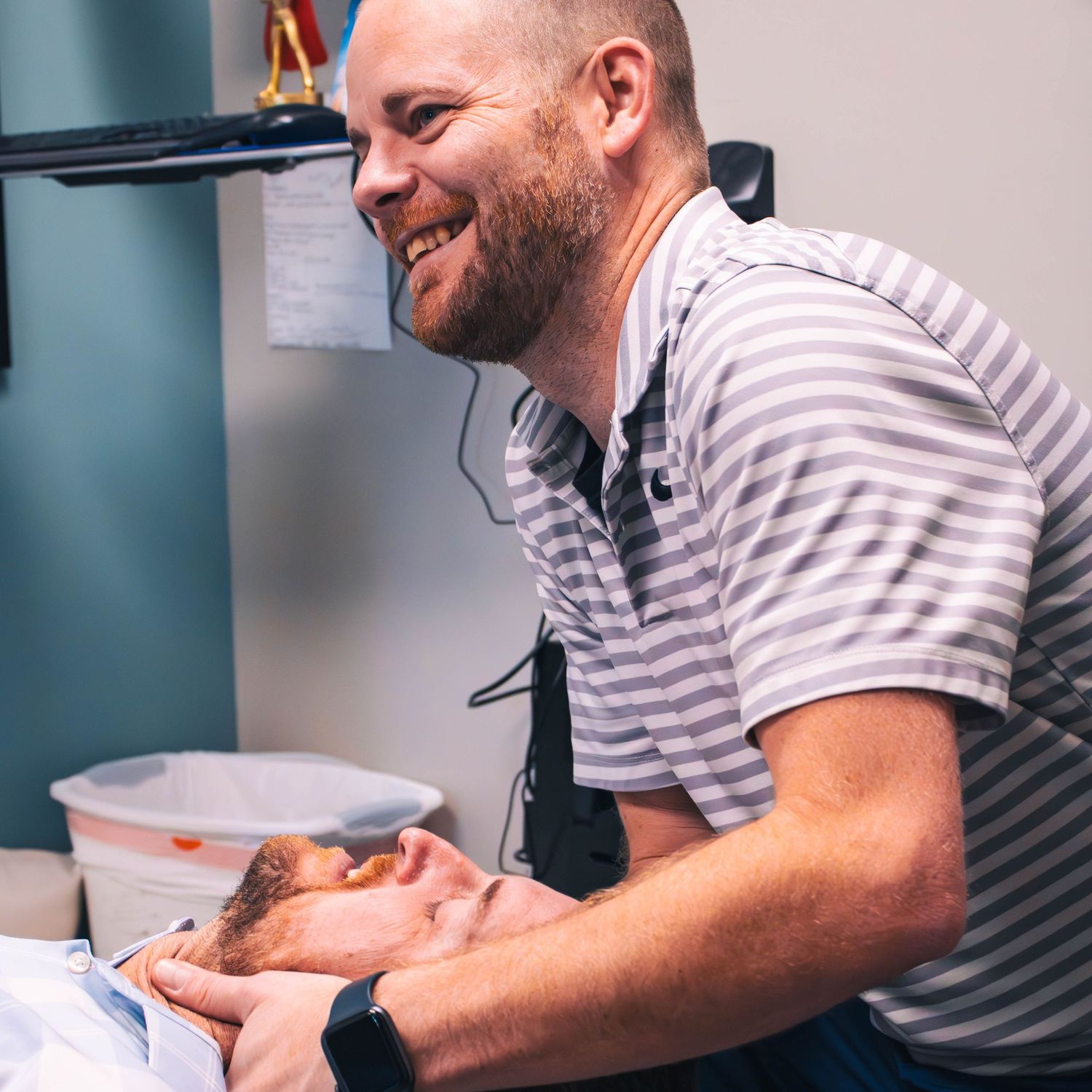 Healthcare provider smiles while providing pediatric care in medical office.