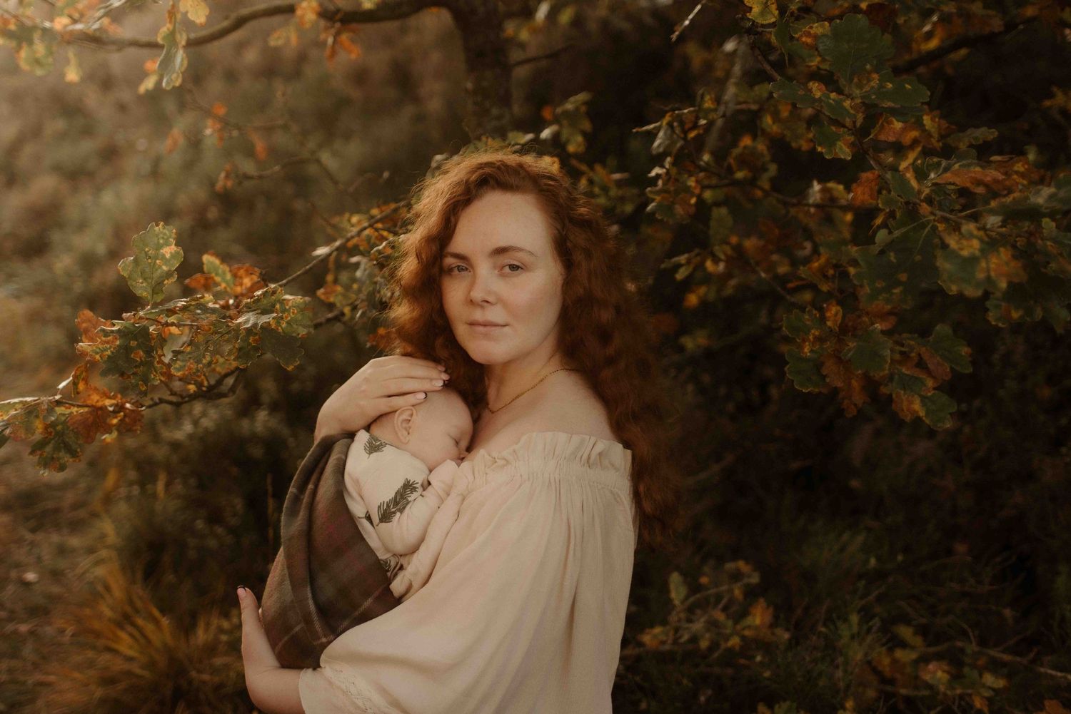 Dreamy autumn portrait of mother holding baby during a motherhood photoshoot at Healey Nab in Chorley
