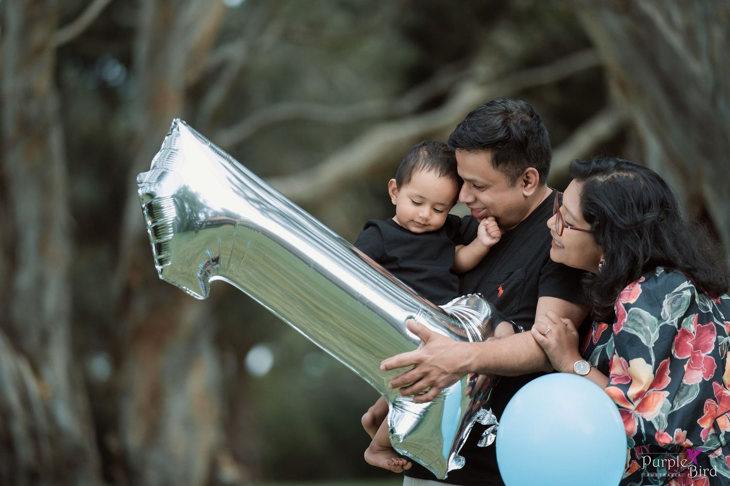 Parents hold their baby beside a silver number one balloon - first birthday family photoshoot, Wollongong family photographer