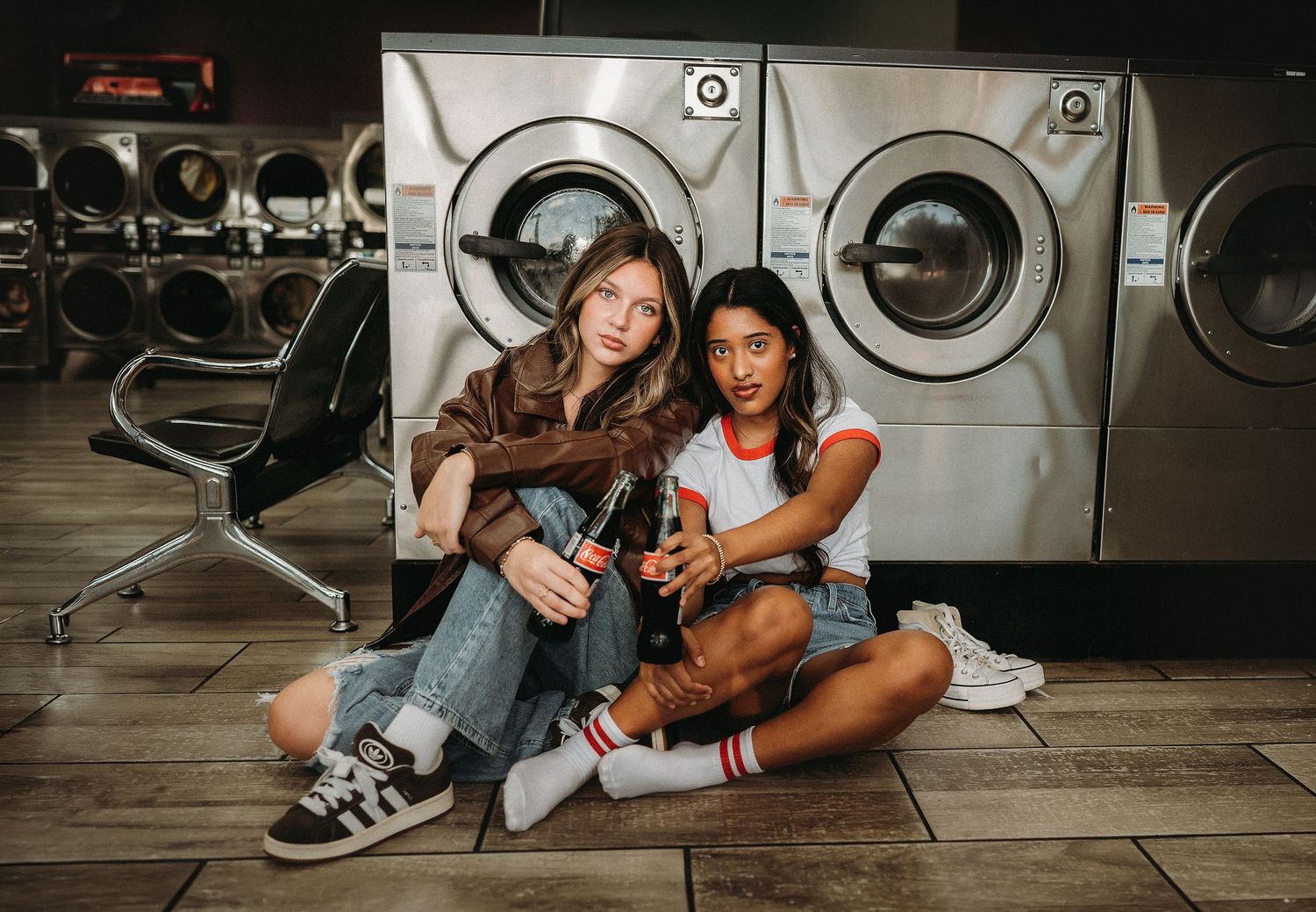 2 friends in a laundromat in front of a washer