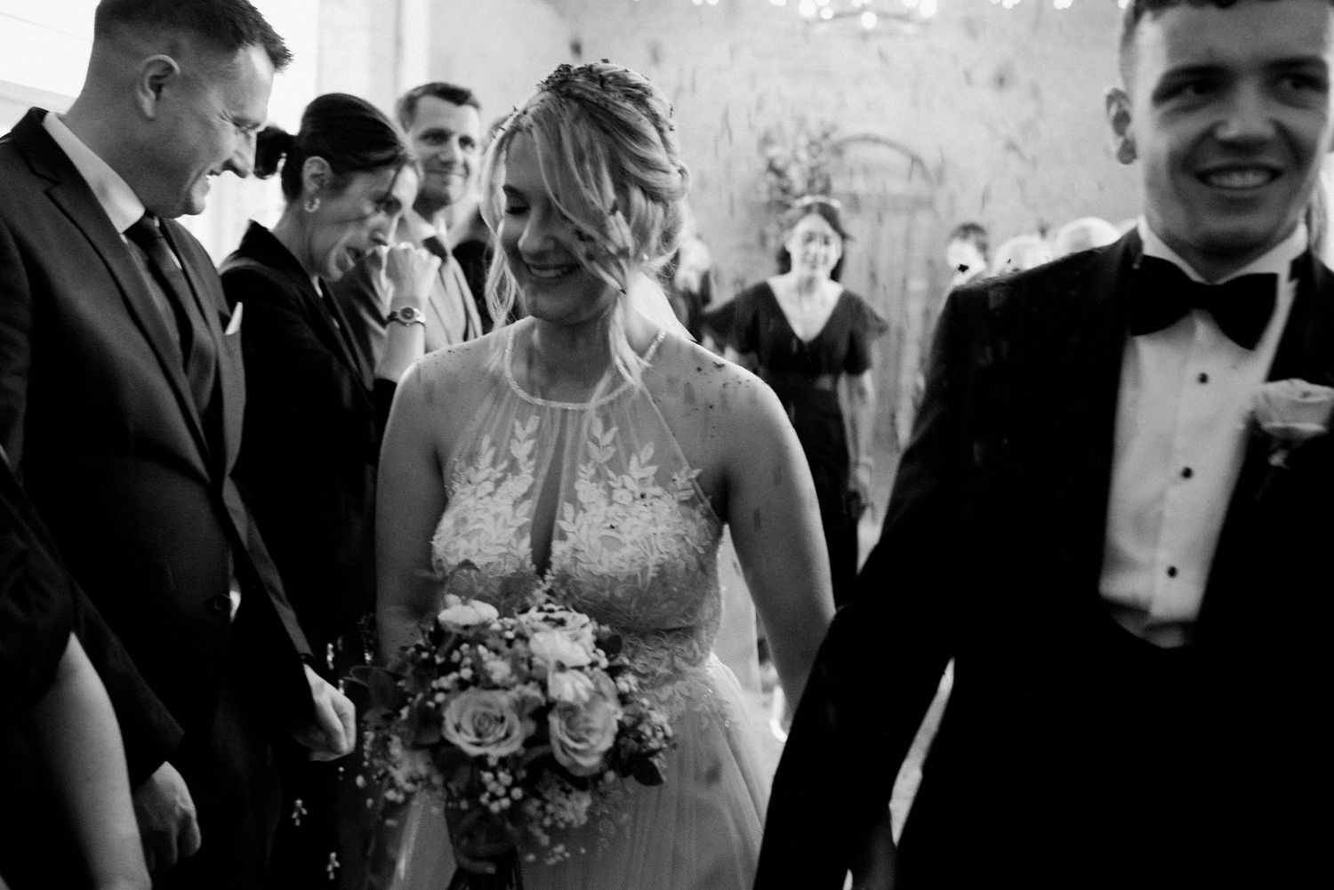 Black and white wedding photo collage showing candid moments of couples and guests at a formal celebration.