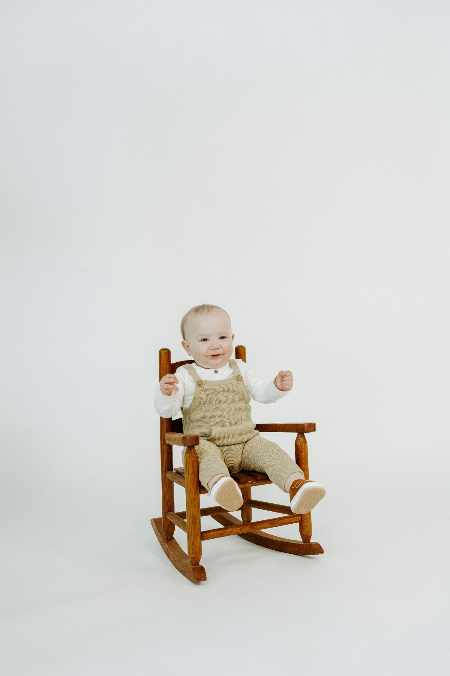A series of four photos showing a small wooden rocking bench with a baby exploring it from different angles.