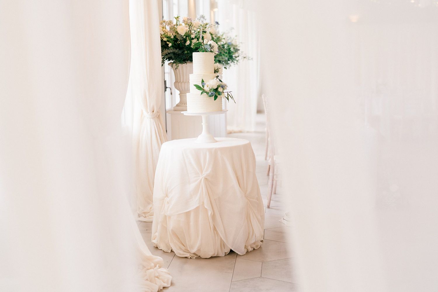 A row of elegant white wedding dresses displayed in a bright, airy bridal boutique interior.