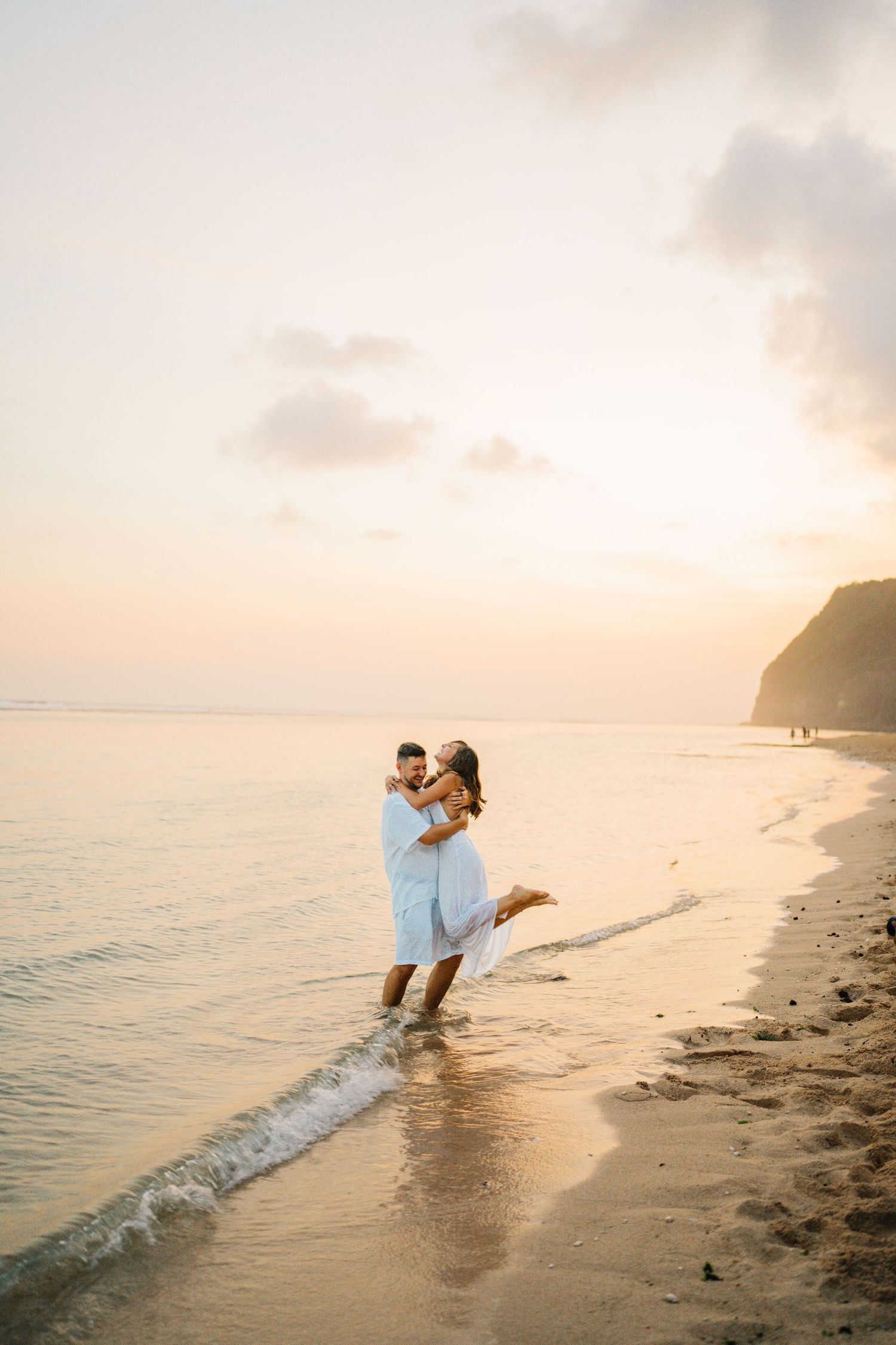 Romantic beach photoshoot with couple at sunset.
