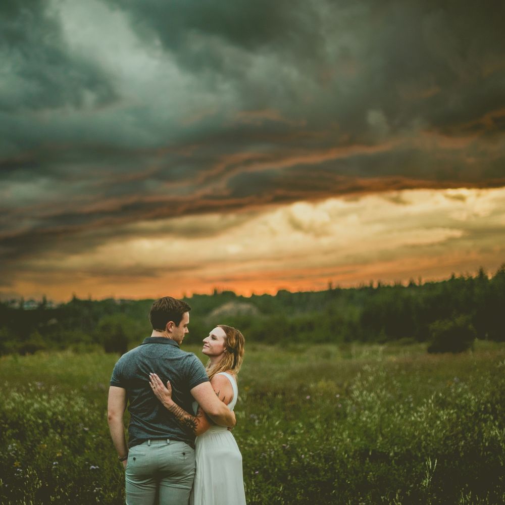 A group poses together outdoors in St Albert in coordinated pastel outfits for a casual family photo session in a natural setting.