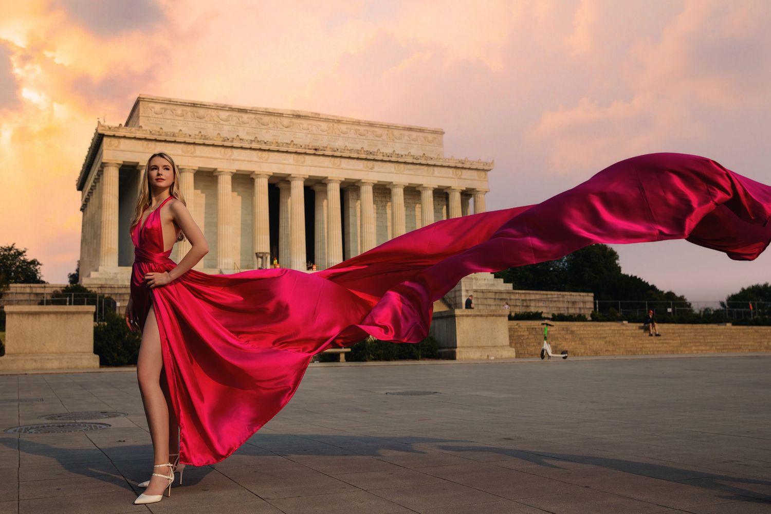 A flowing red dress billows dramatically against the backdrop of the Supreme Court building at sunset. Flying Dress Photoshoot