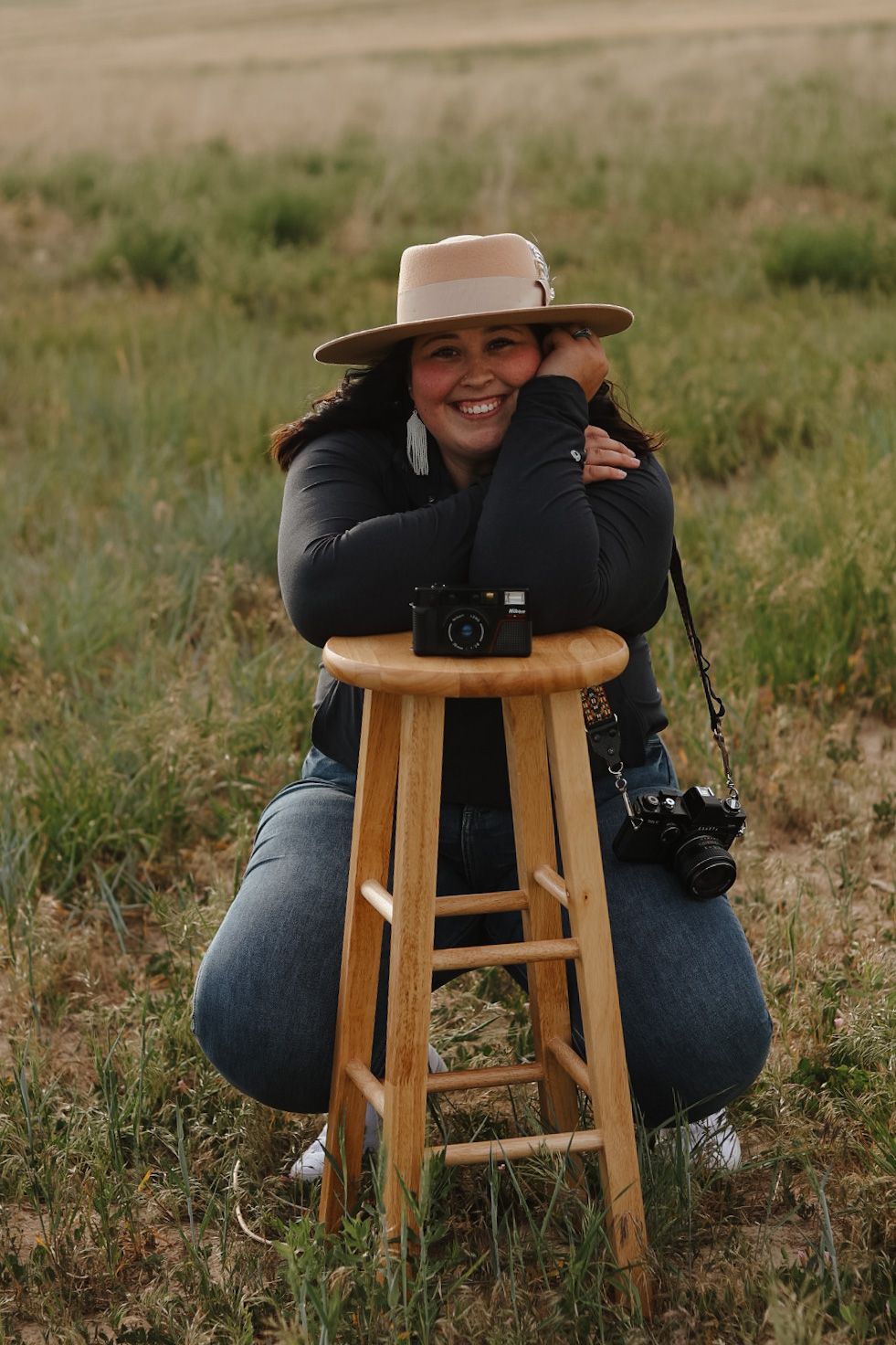 Wooden stool and camera equipment set up in a grassy field.