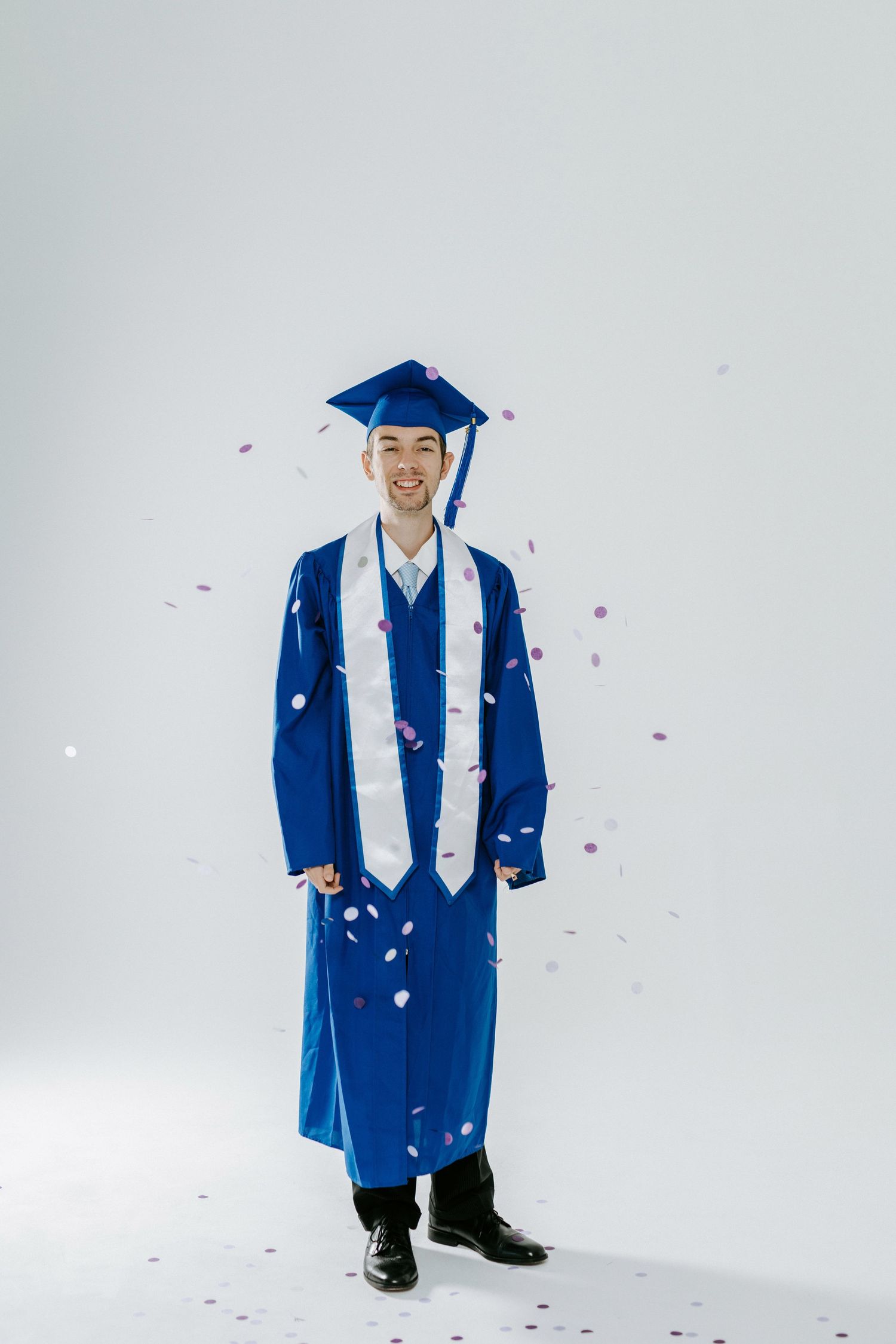 A person wearing a blue graduation gown demonstrates different hand gestures and poses in a sequence of photos.