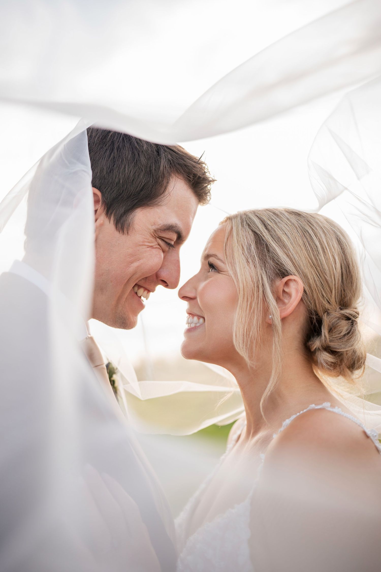 Romantic wedding couple shares intimate moments under a white veil in a series of soft, dreamy photographs.