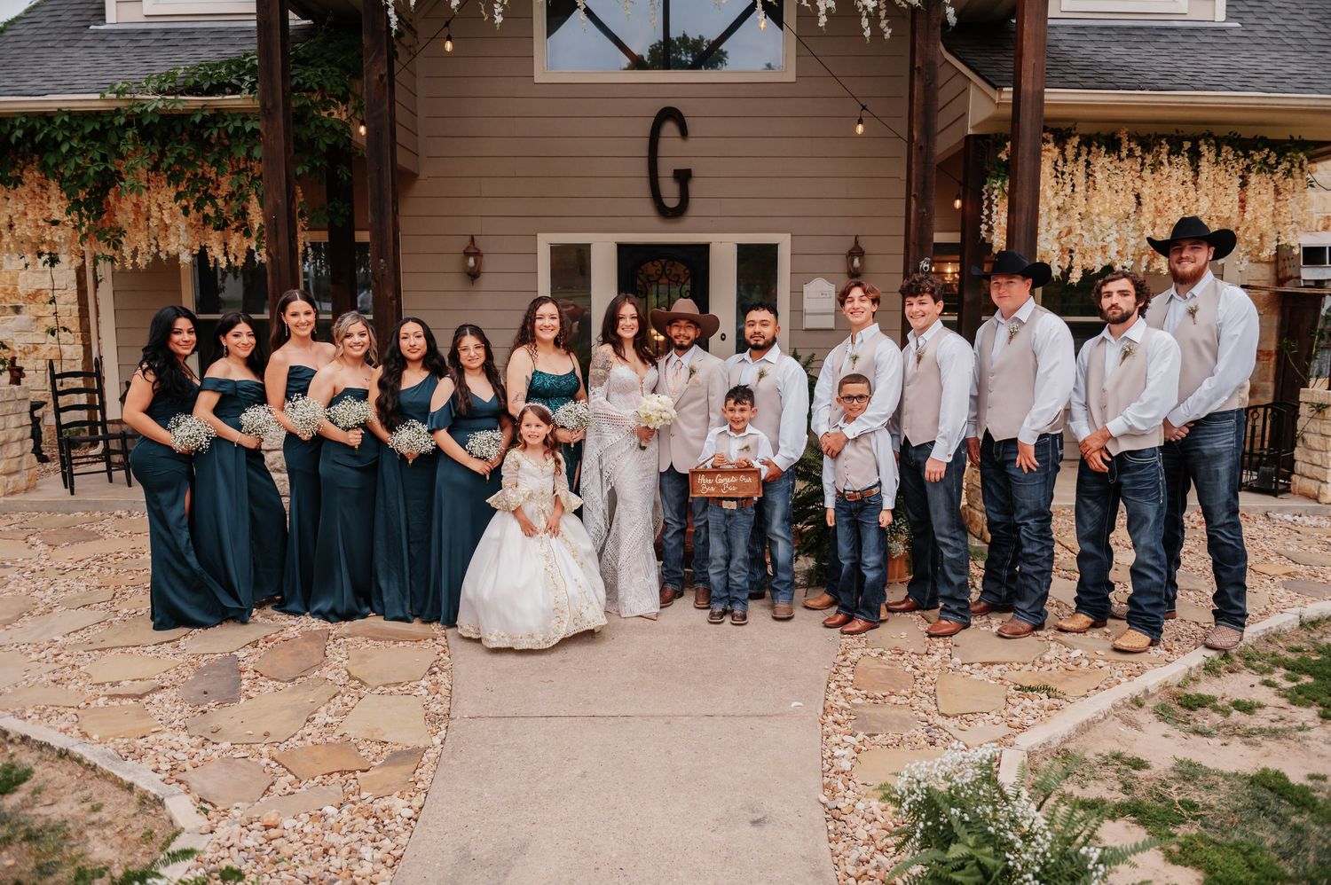 Bride and groom exchange vows at rustic indoor wedding ceremony with white chairs and floral arrangements.