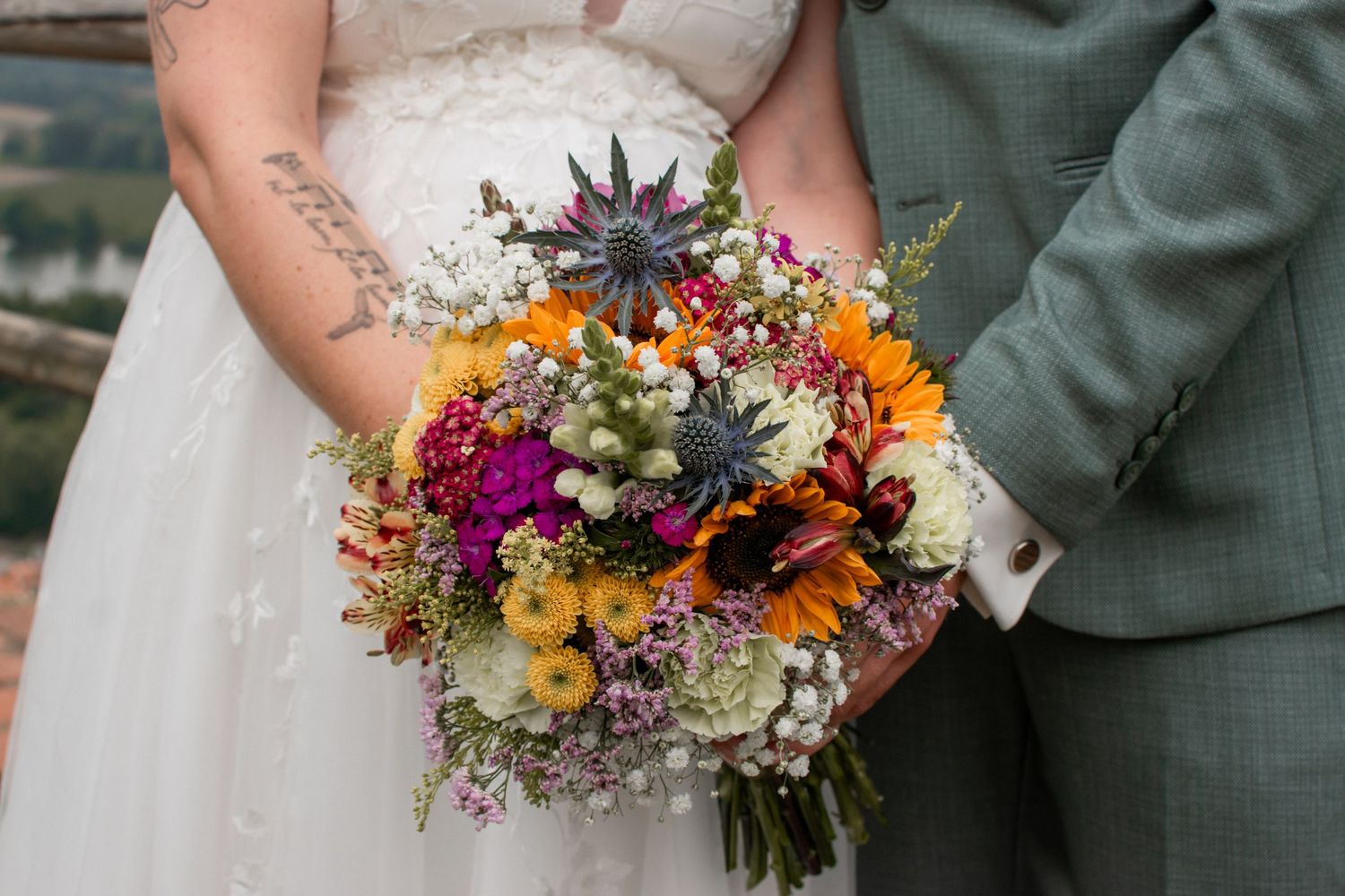 Two newlyweds display their matching silver wedding rings on their ring fingers in a close-up photo.