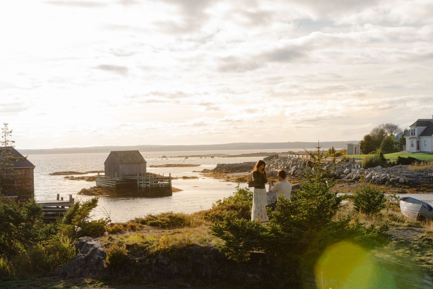 couple proposing at blue rocks, nova scotia on golden sunny day