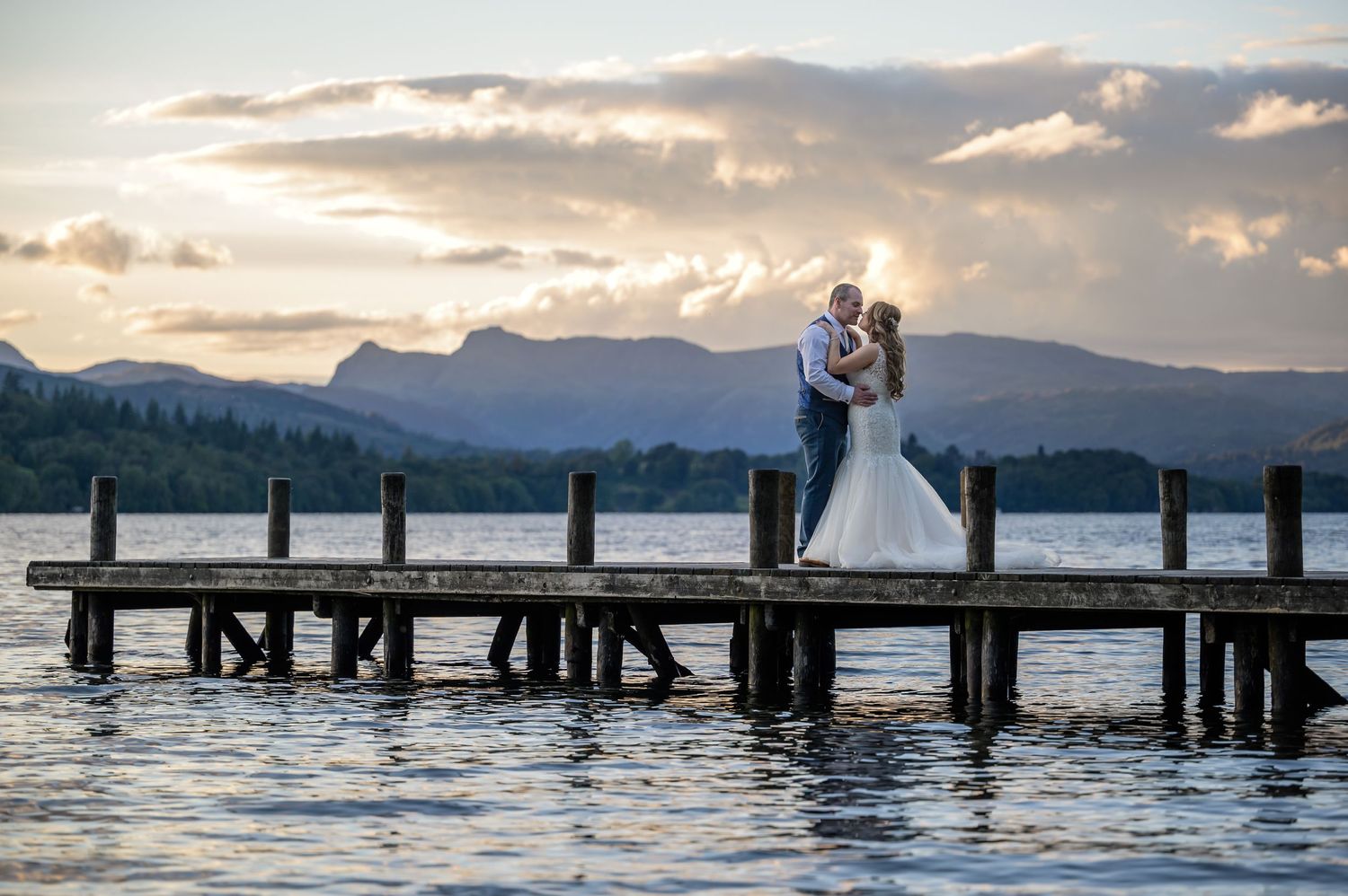 Bride and groom on Windermere jetty at sunset in Lake District