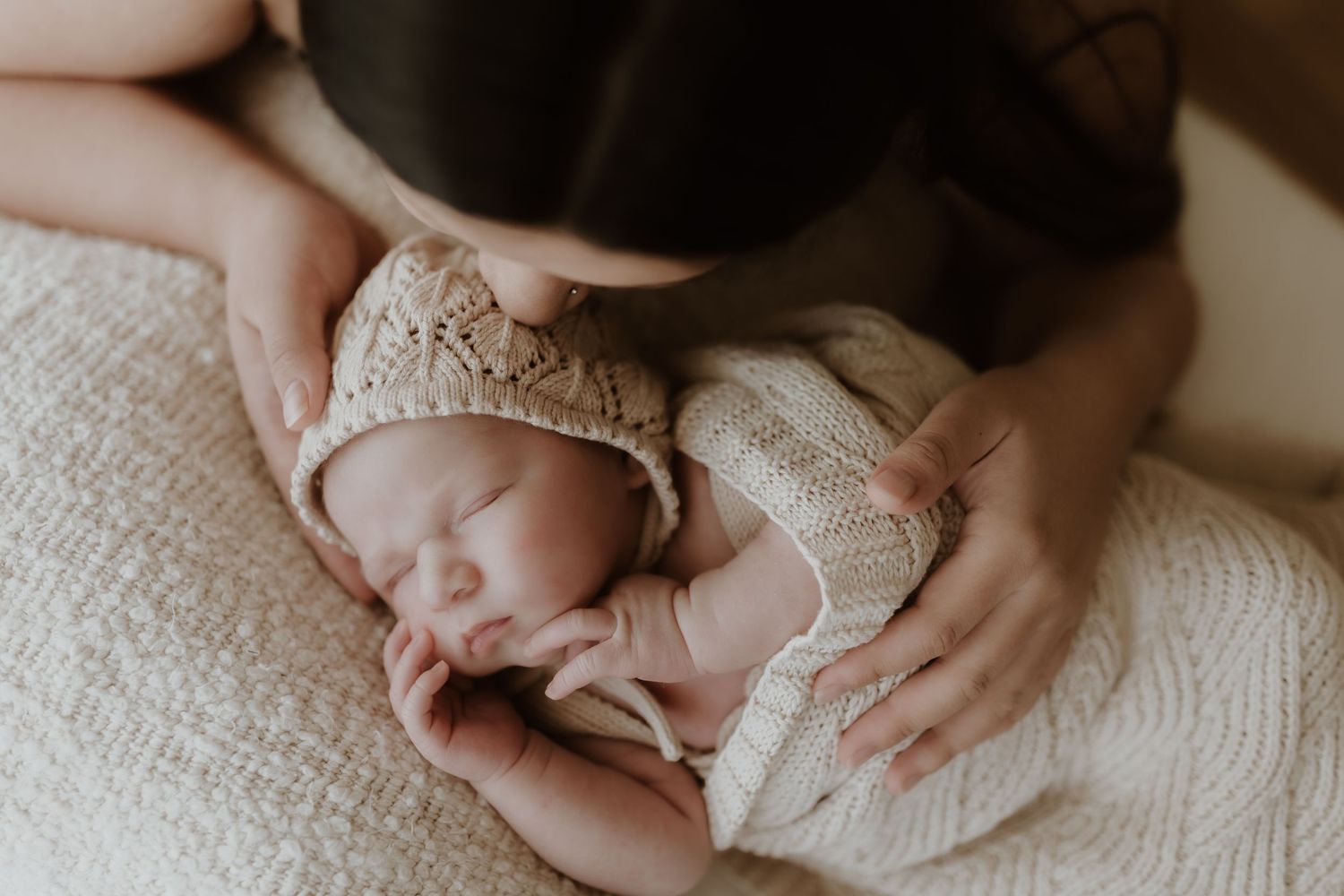 Peaceful sleeping newborn in delicate lace outfit.