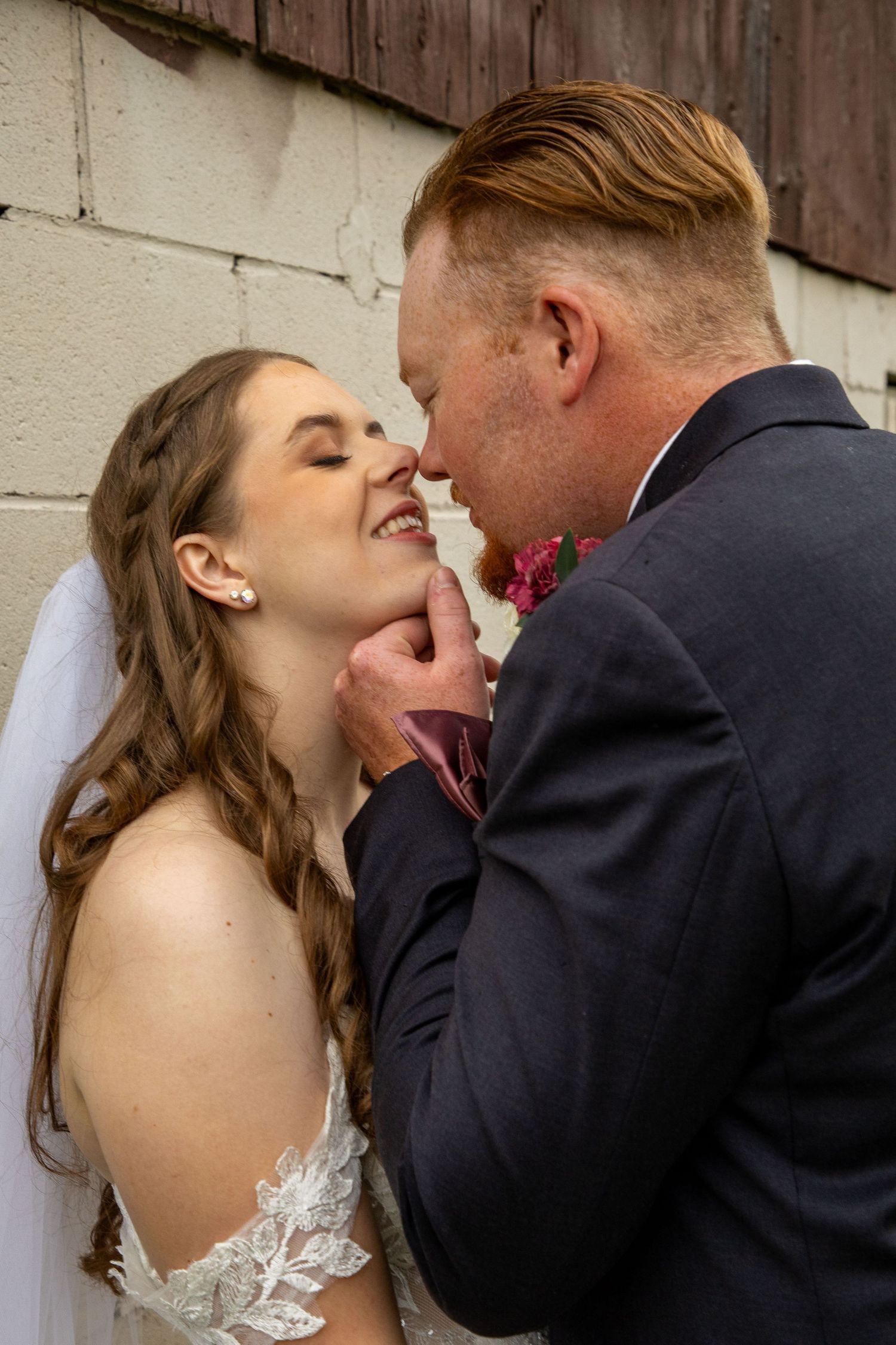 Bride and groom about to kiss by the basement of The Lotus Barn in Uxbridge