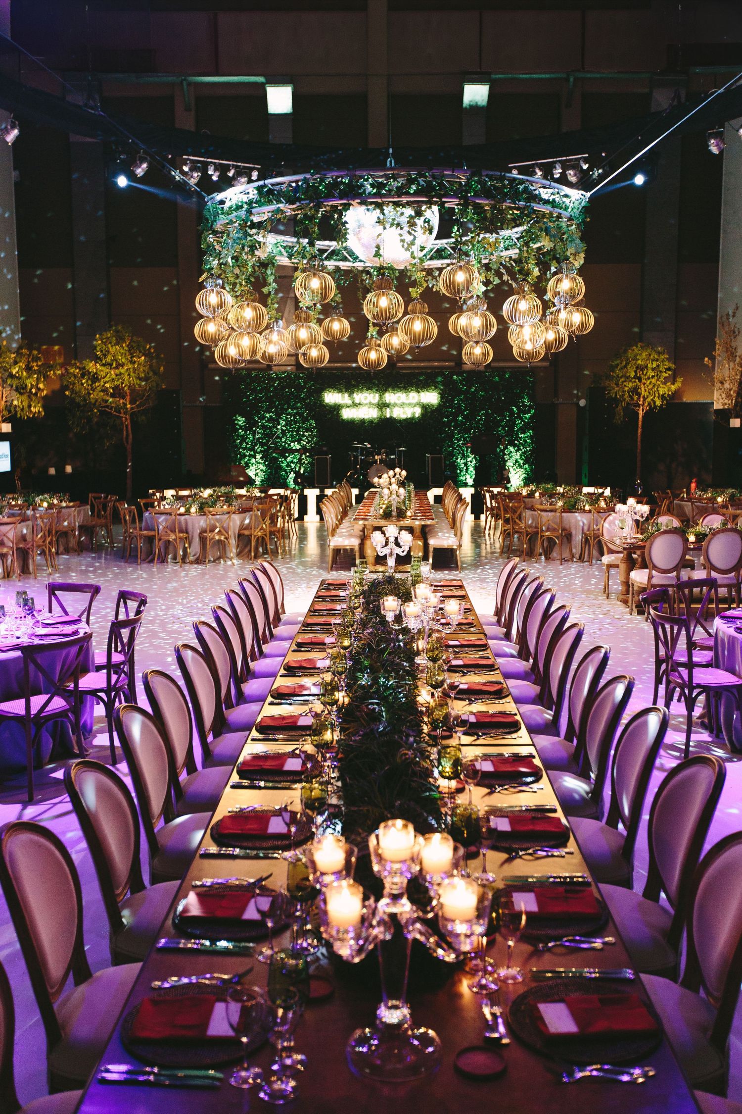 Grand ballroom with ornate ceiling, crystal chandeliers and long tables set for an elegant wedding reception.
