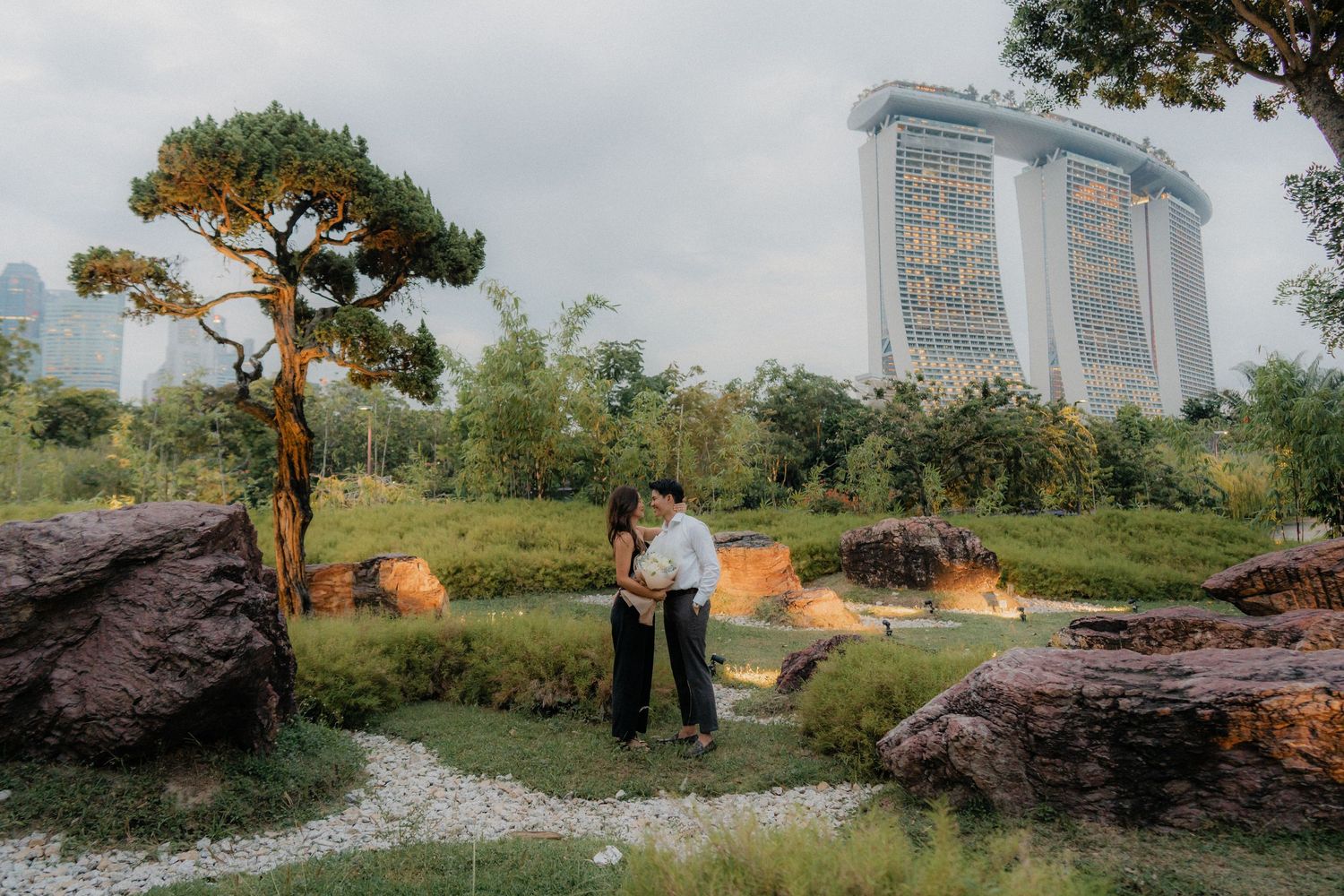 Garden scene with Singapore's iconic Marina Bay Sands towers visible in background.