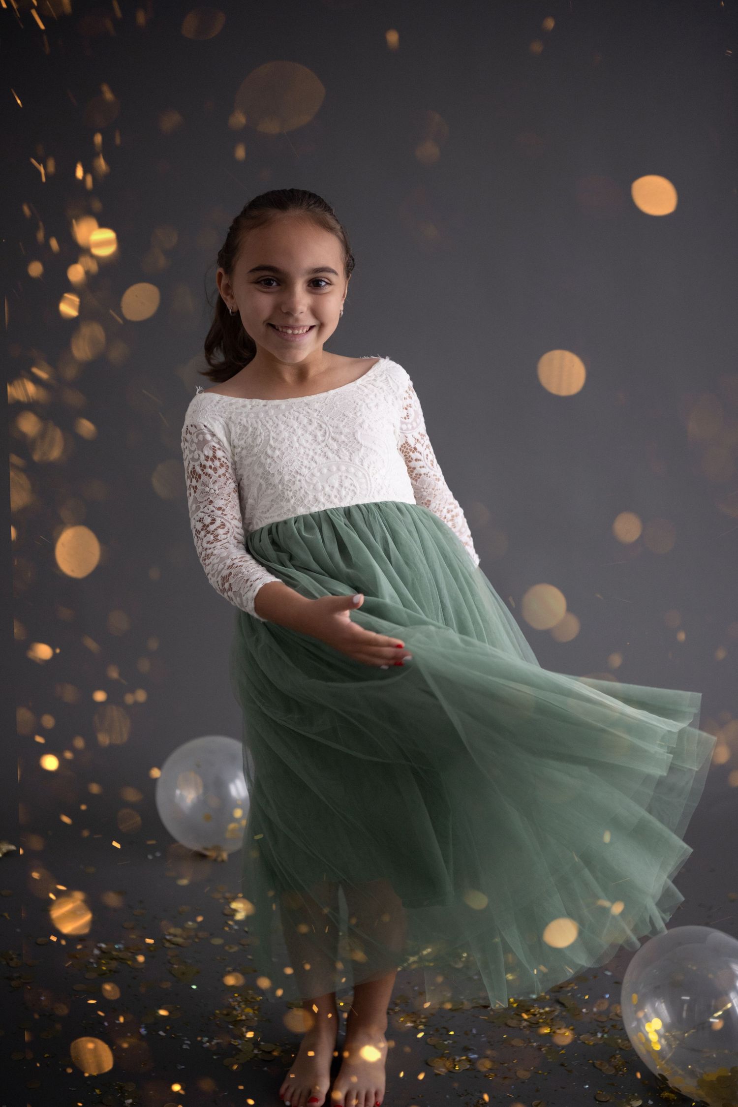 Elegant party dresses in black, pink, and white with gold and silver balloons on dark gray background.
