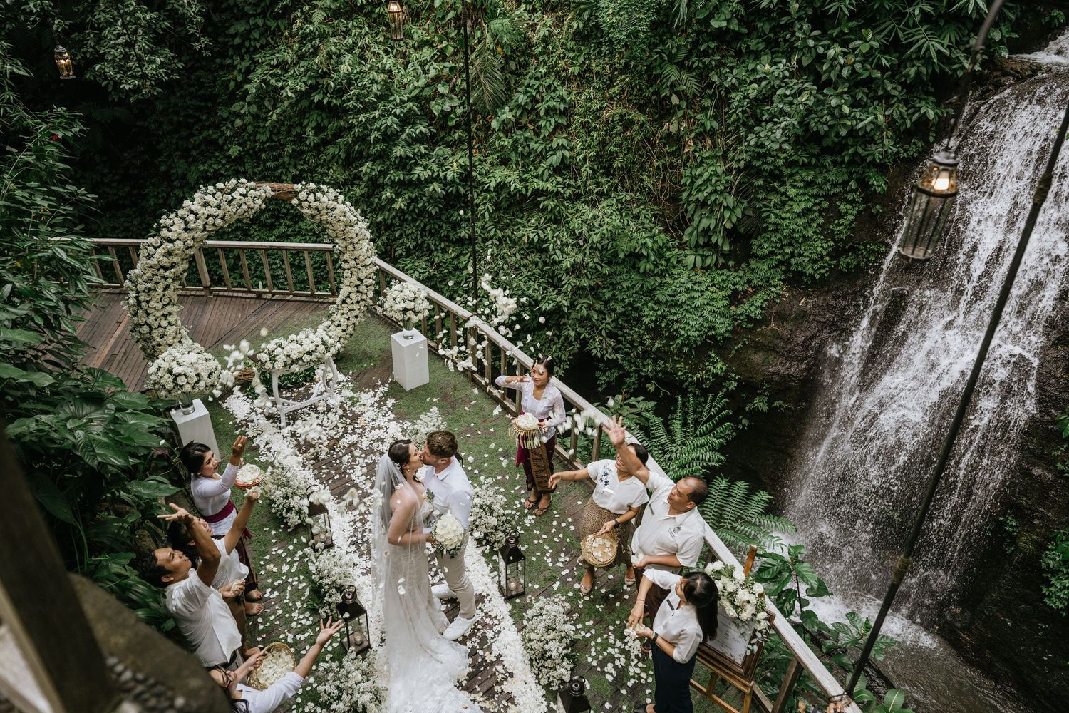 Outdoor wedding ceremony setup in a lush green forest setting with floral decorations.