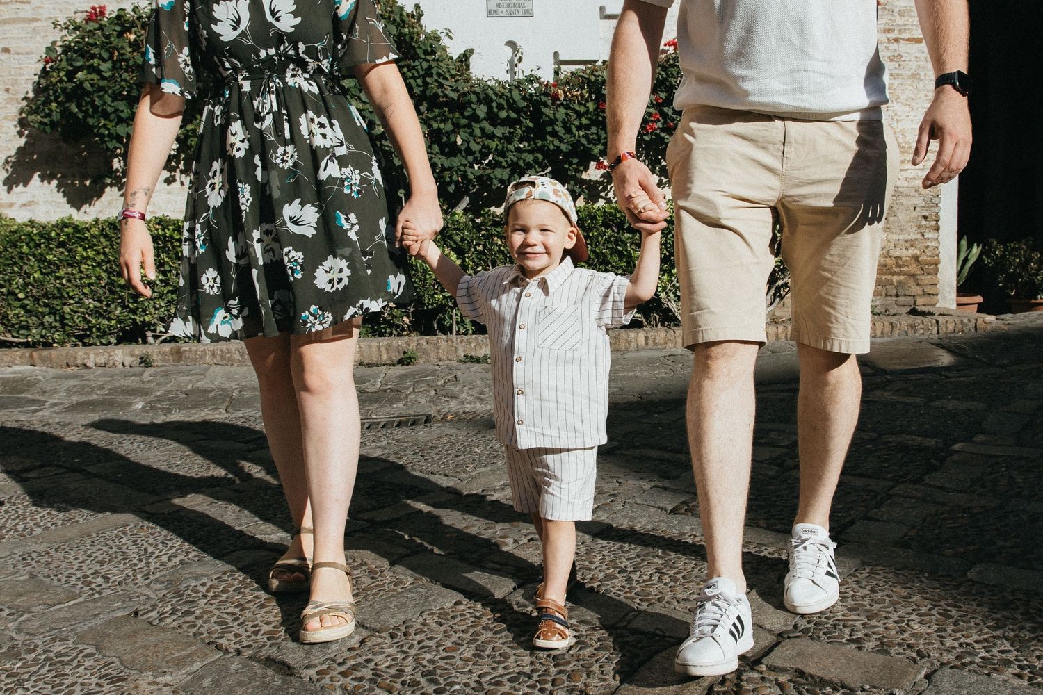 Low angle view of people's legs walking together on a path during a sunny day.