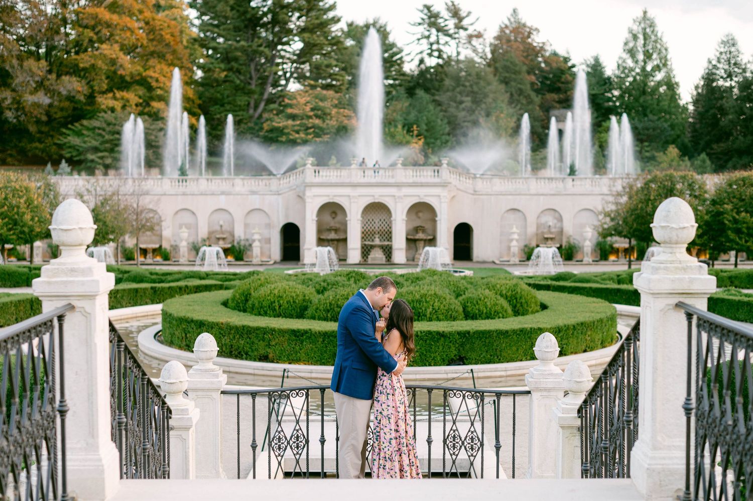 White stone architecture and garden fountains create an elegant backdrop for a couple's photography session.