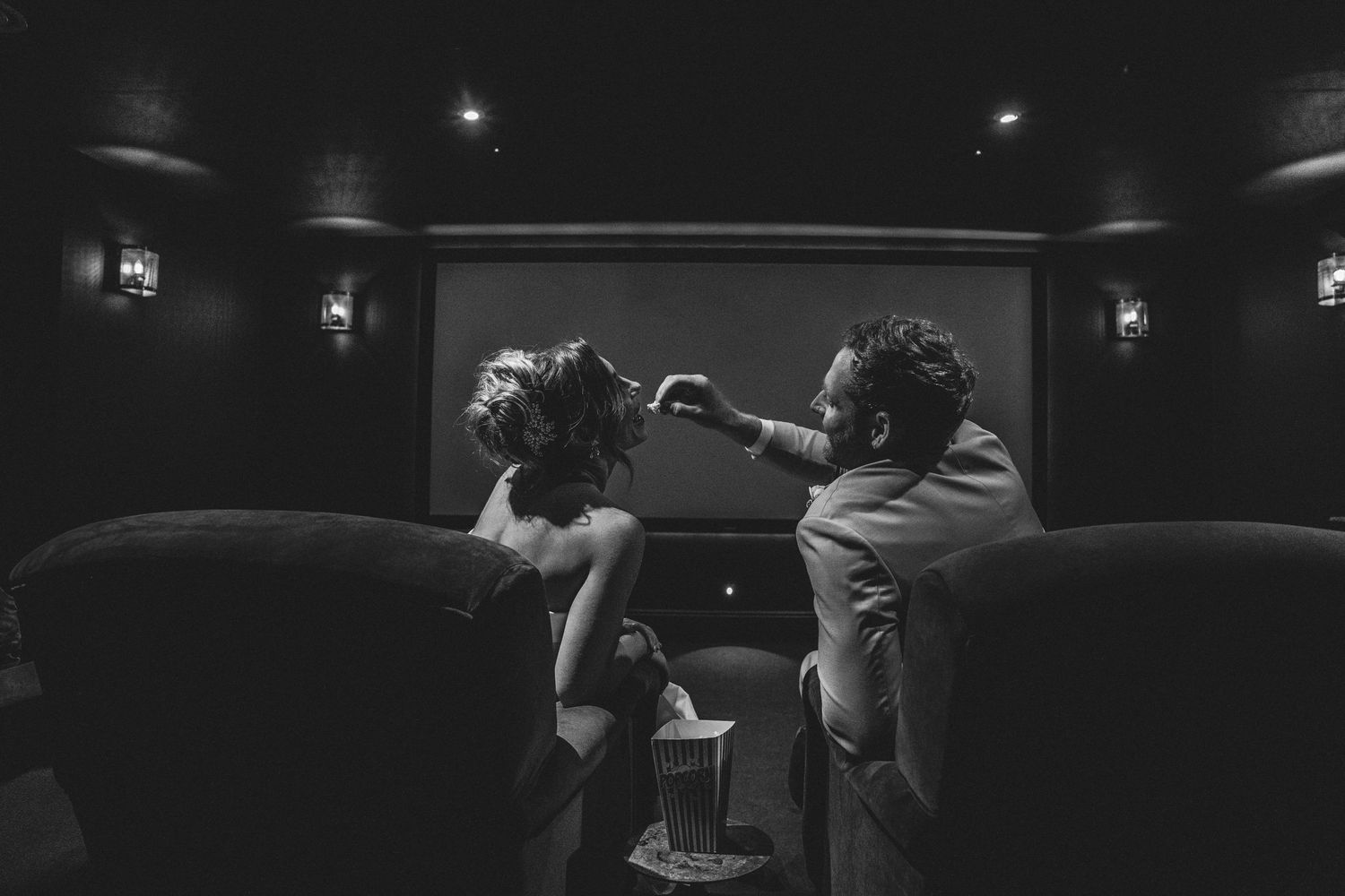 Bride and groom laughing together in the private cinema at Gara Rock Hotel, Devon