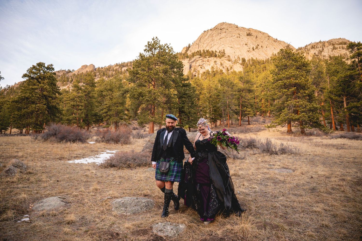 A panoramic view of people enjoying a scenic mountain landscape during golden hour at a state park.