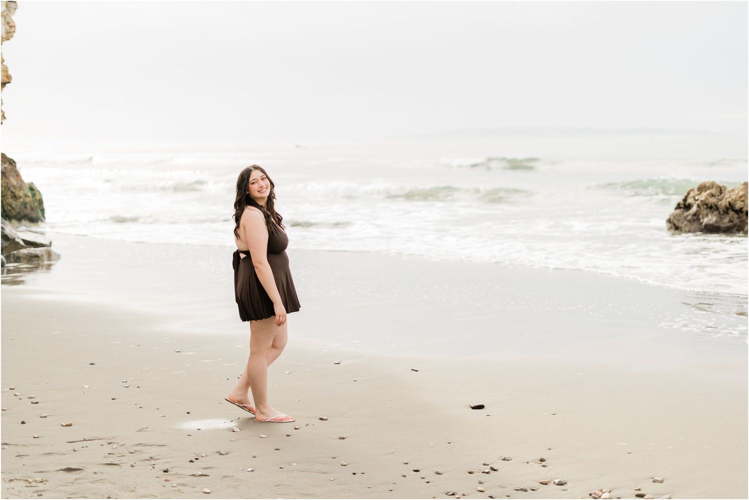 Senior Session in Avila Beach on cloudy day. senior in brown dress walking on the beach | senior photos by felisha connolly