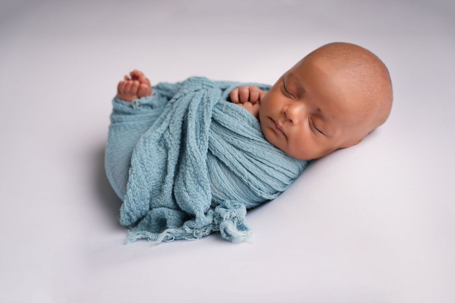 New born photoshoot Dubai showing studio setup vs home lifestyle session with baby in cozy nursery and professional lighting setup