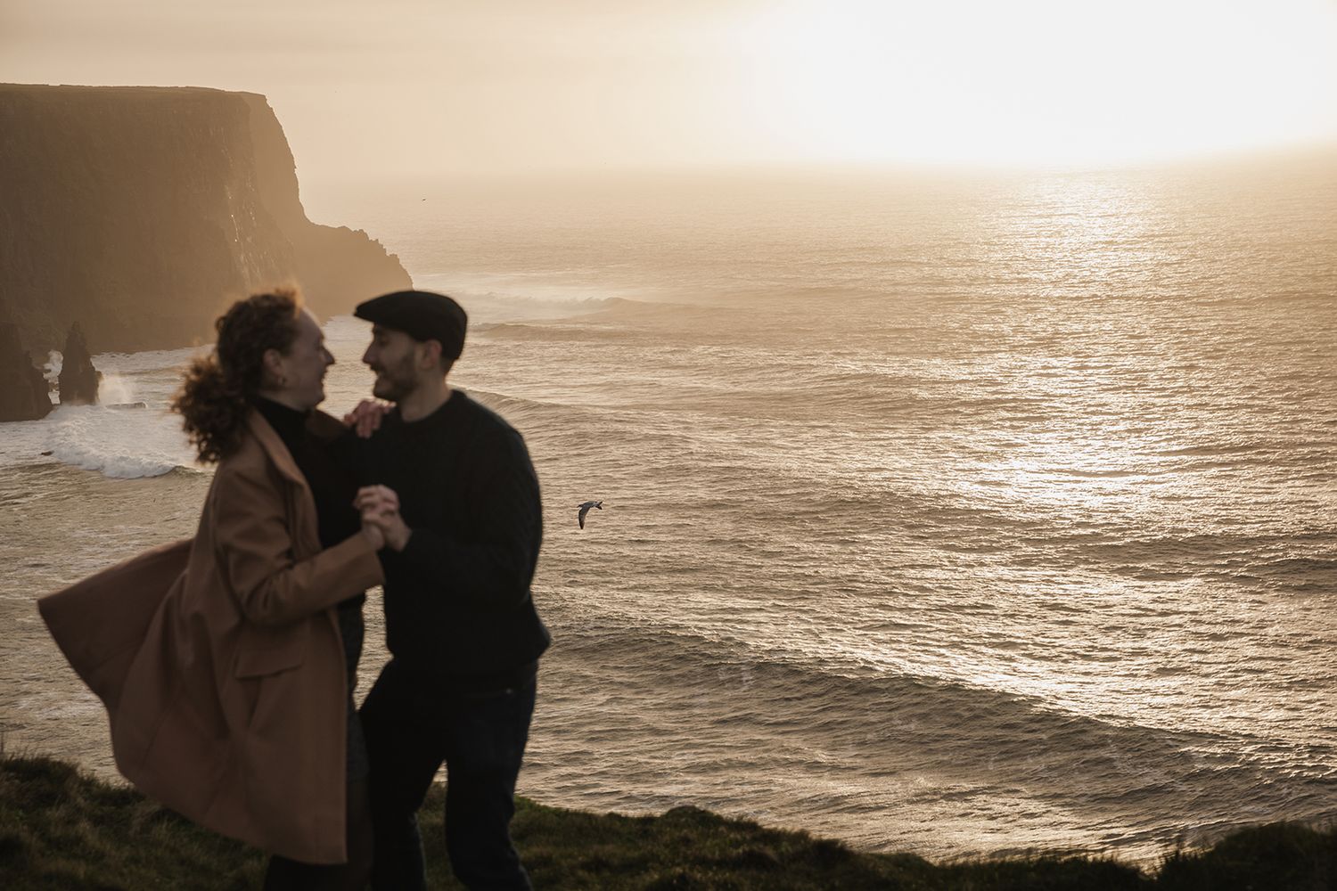 Cinematic couple portraits at sunset along Doolin Cliff Walk overlooking the Atlantic Ocean