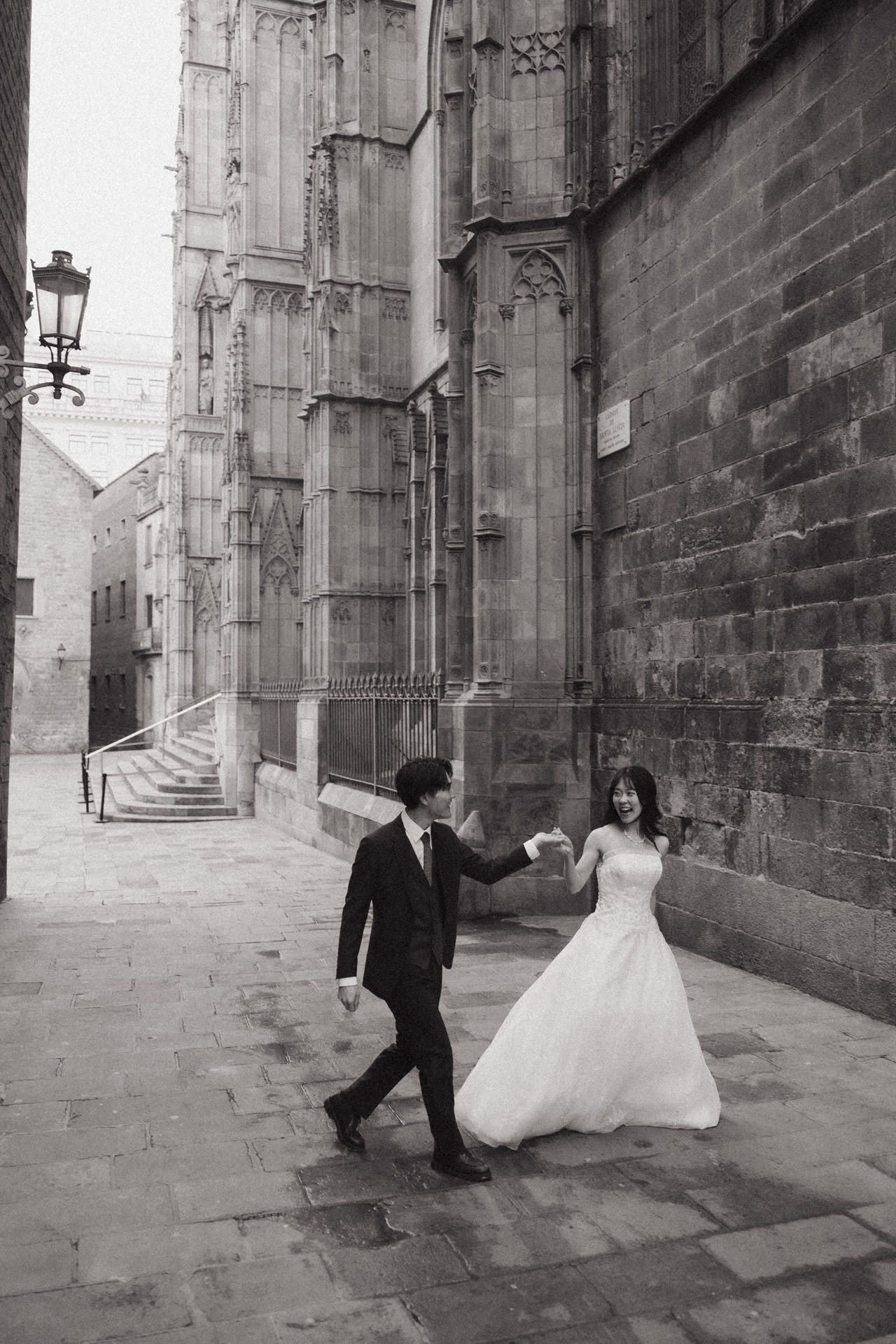 A sequence of black and white wedding photos showing a couple dancing playfully in a historic stone alleyway.
