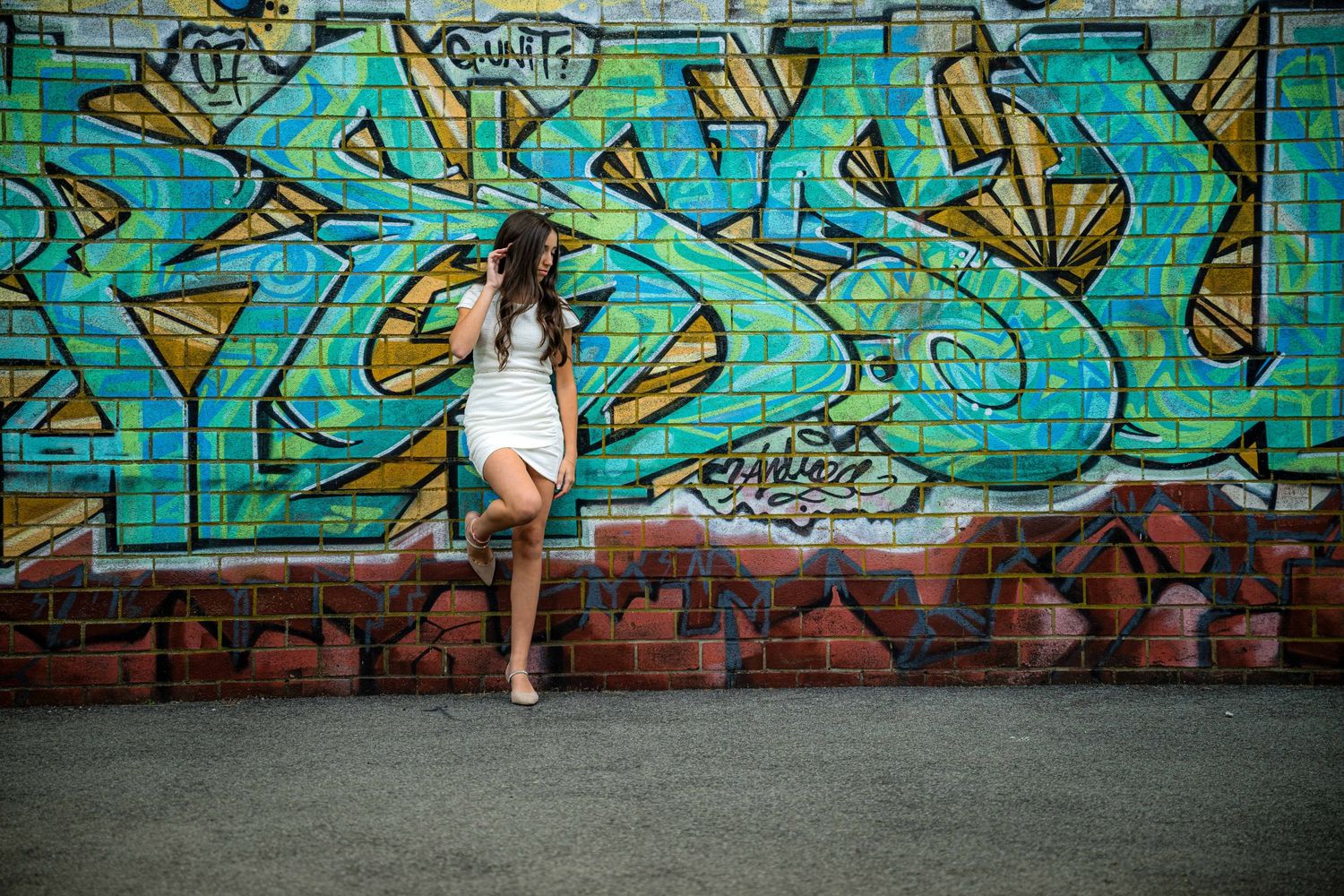 Modern senior graduation portrait taken in Purchase Collage Mamaroneck NY, featuring a stylish graduate against an urban cityscape.