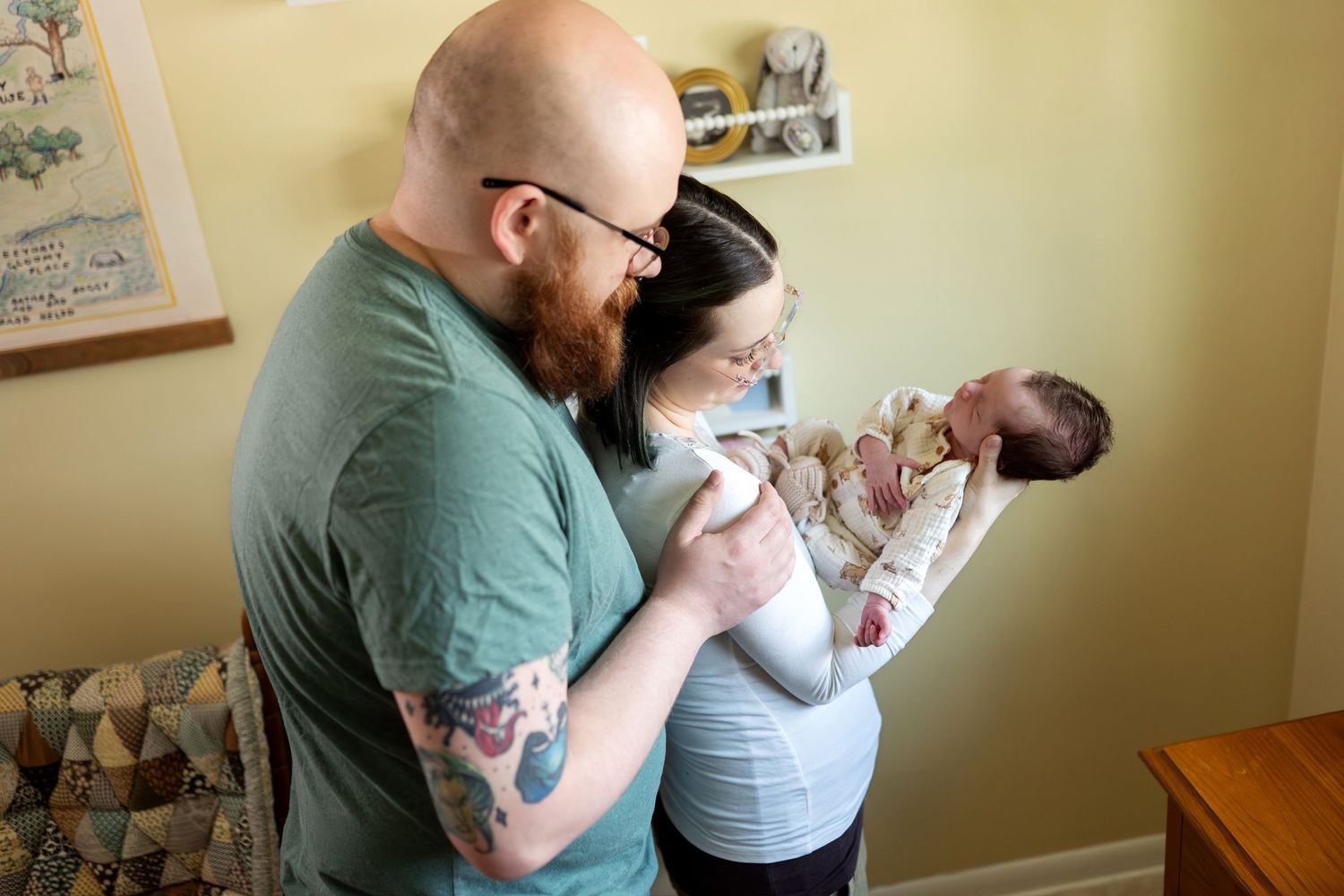 New parents admiring their newborn baby in a warmly decorated nursery room.