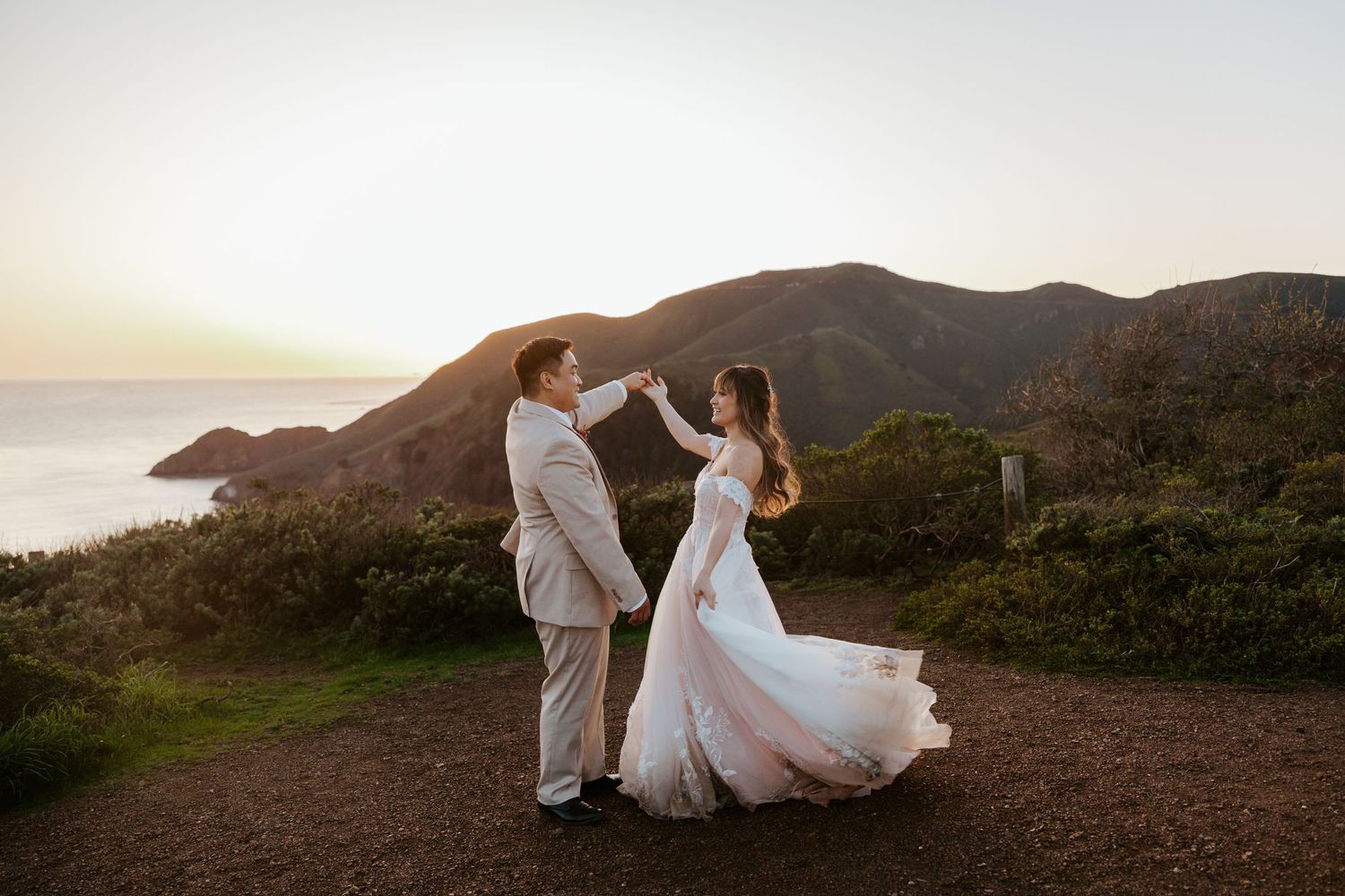 groom holding bride's hand while bride twirls wedding dress at sunset during san francisco elopement day