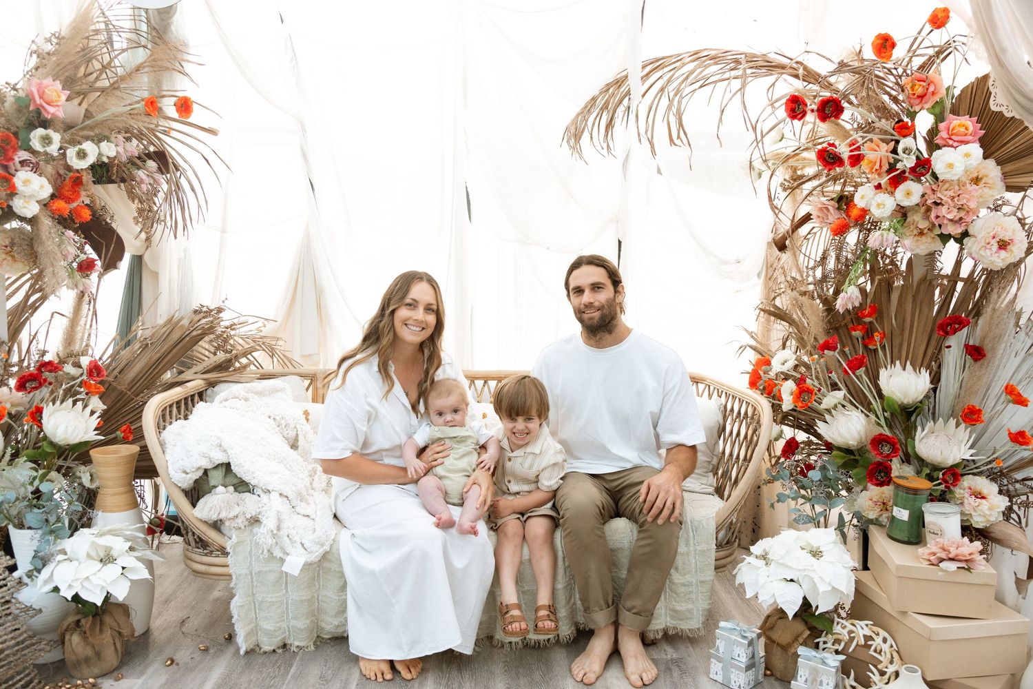 Family holiday portrait with rustic floral arrangements and white Christmas decorations.