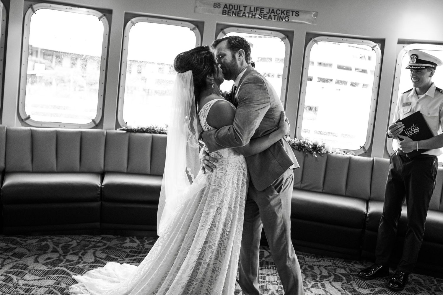 A romantic black and white photo showing a couple in wedding attire sharing an intimate moment in a park setting.