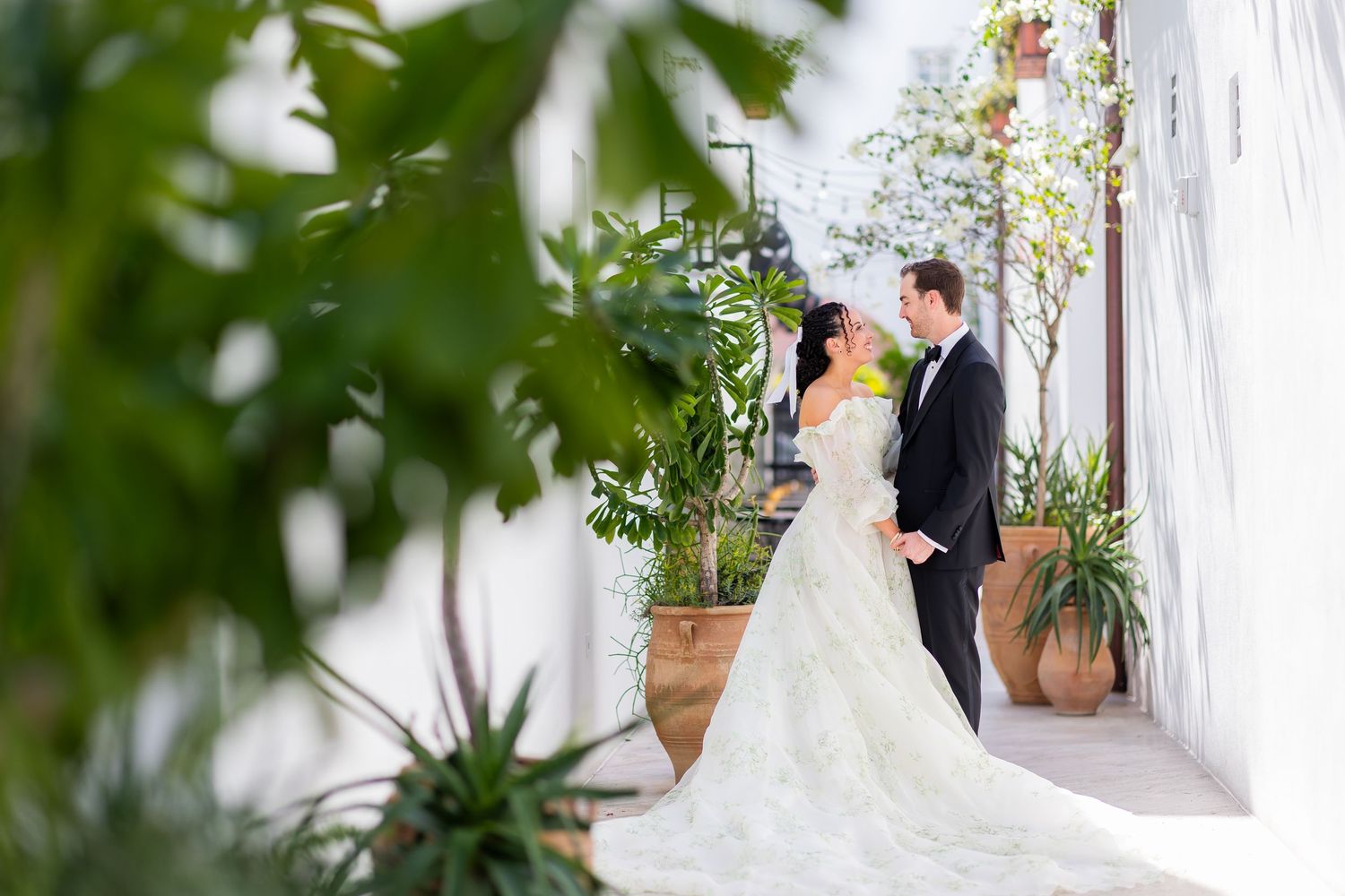 Romantic outdoor garden wedding portraits with white floral arrangements.