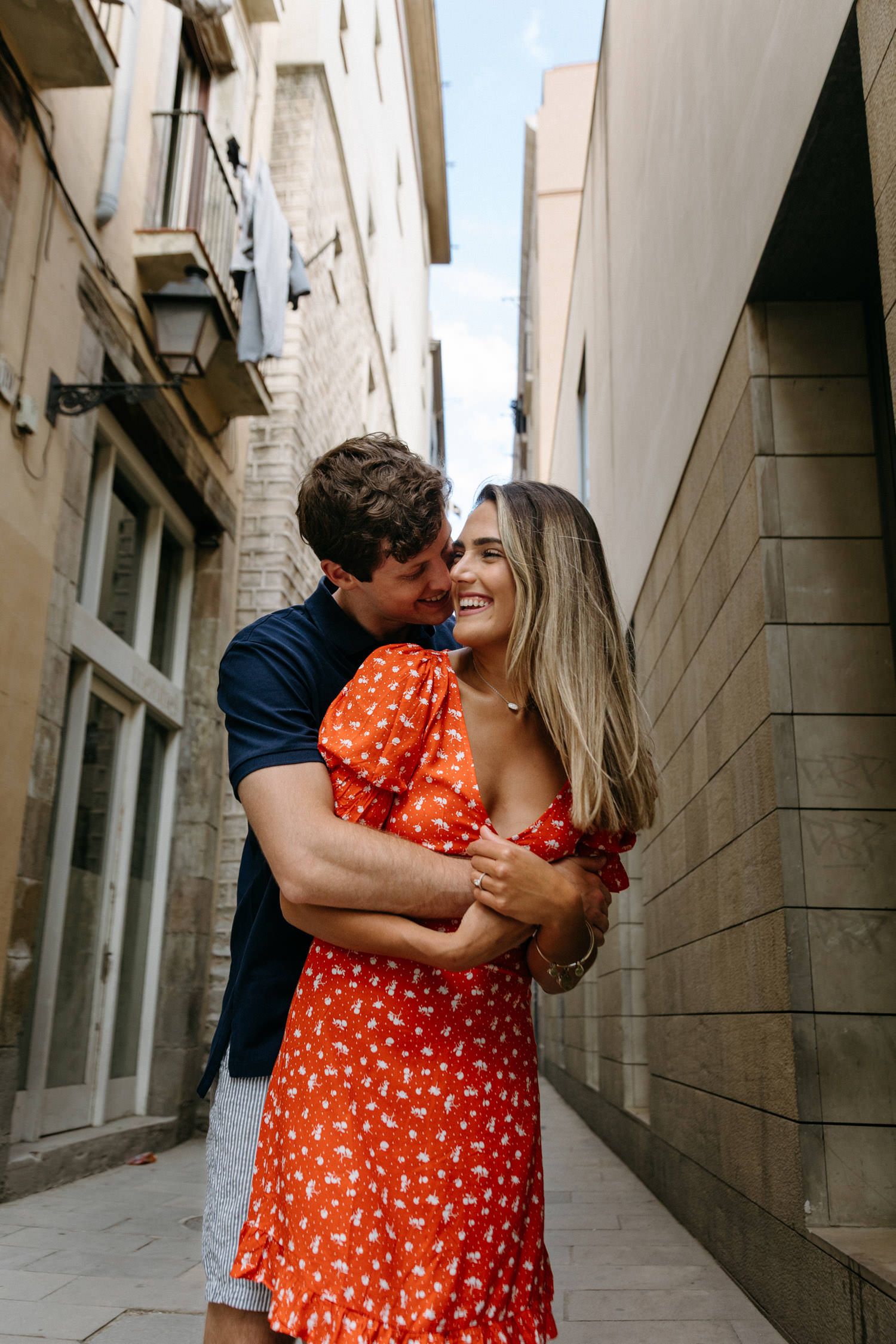 Romantic couple embracing in an alley with brick buildings.