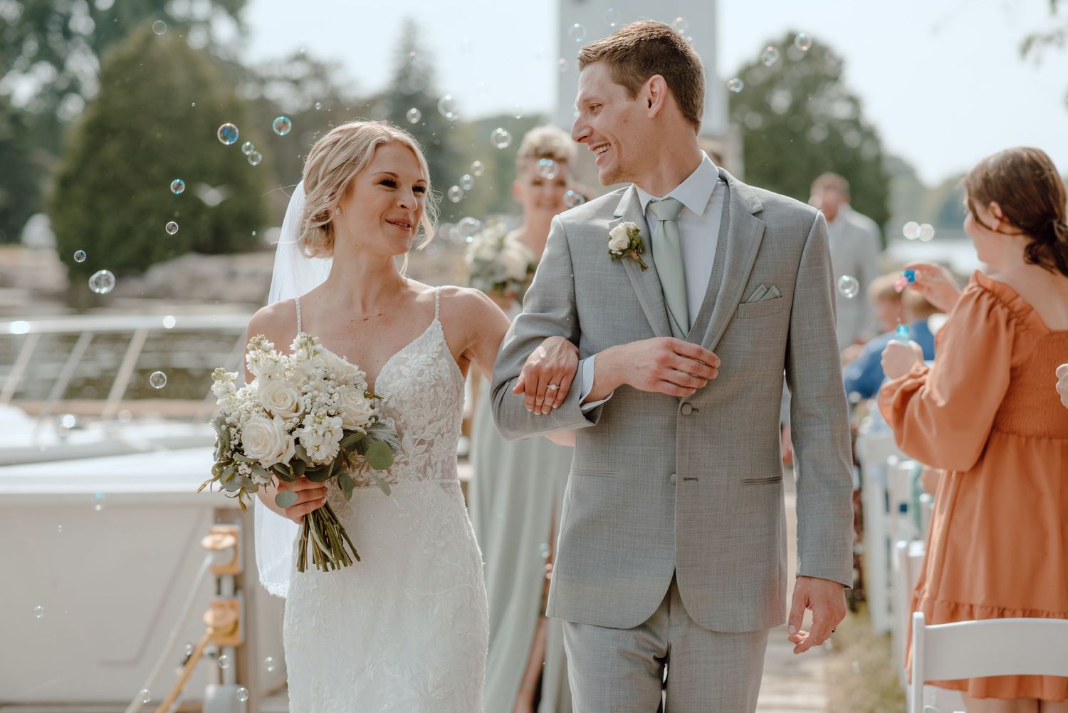 A joyful couple celebrating their wedding ceremony on a boat dock on a sunny day.