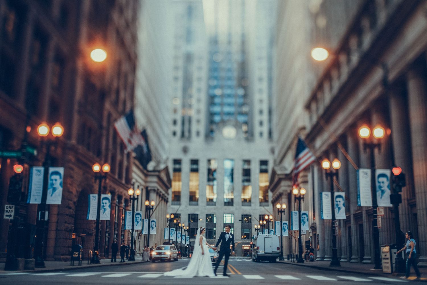 A couple poses on LaSalle Street in Chicago with the Board of Trade building and vintage lampposts in the background.